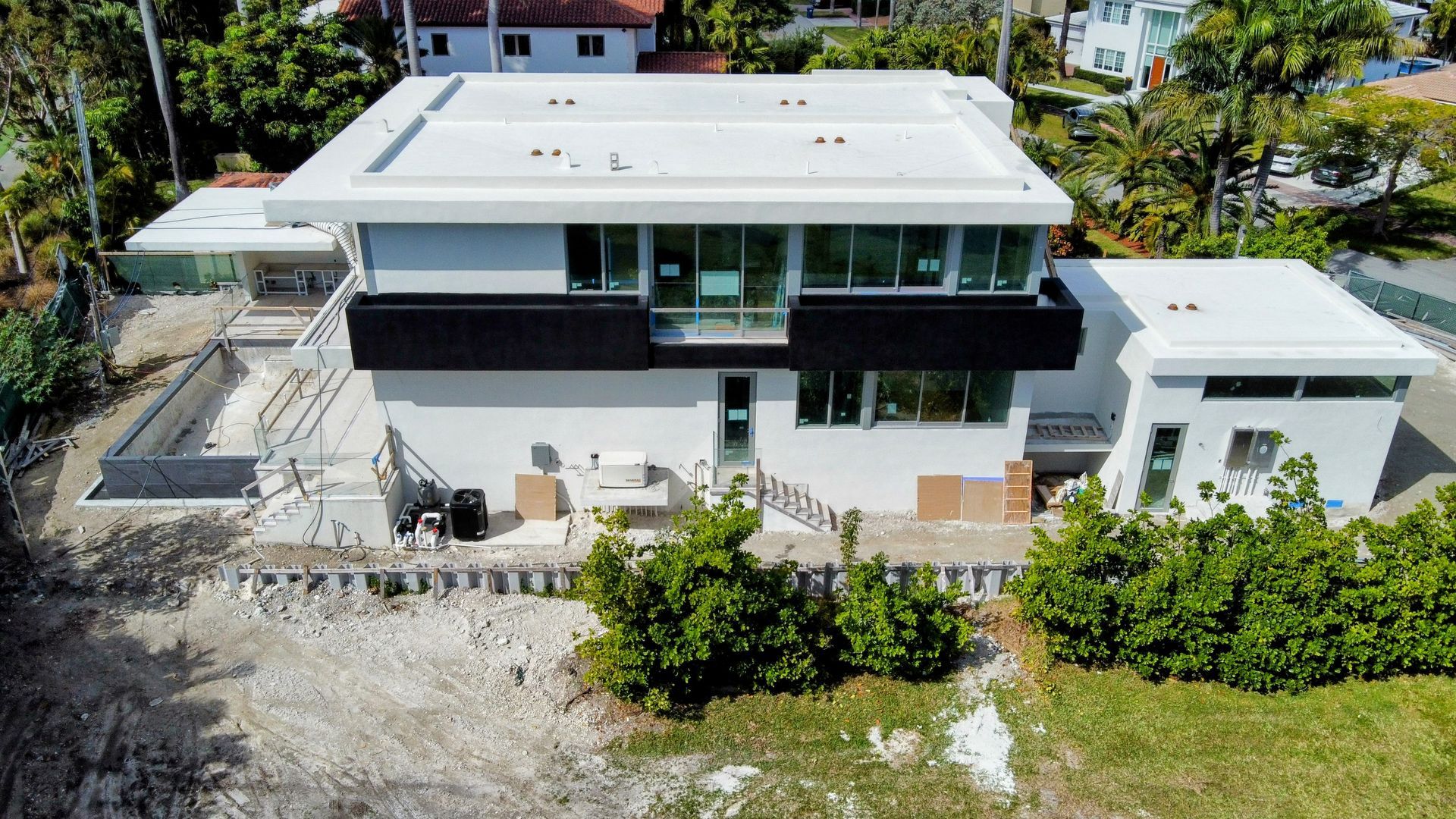An aerial view of a large white house surrounded by trees.