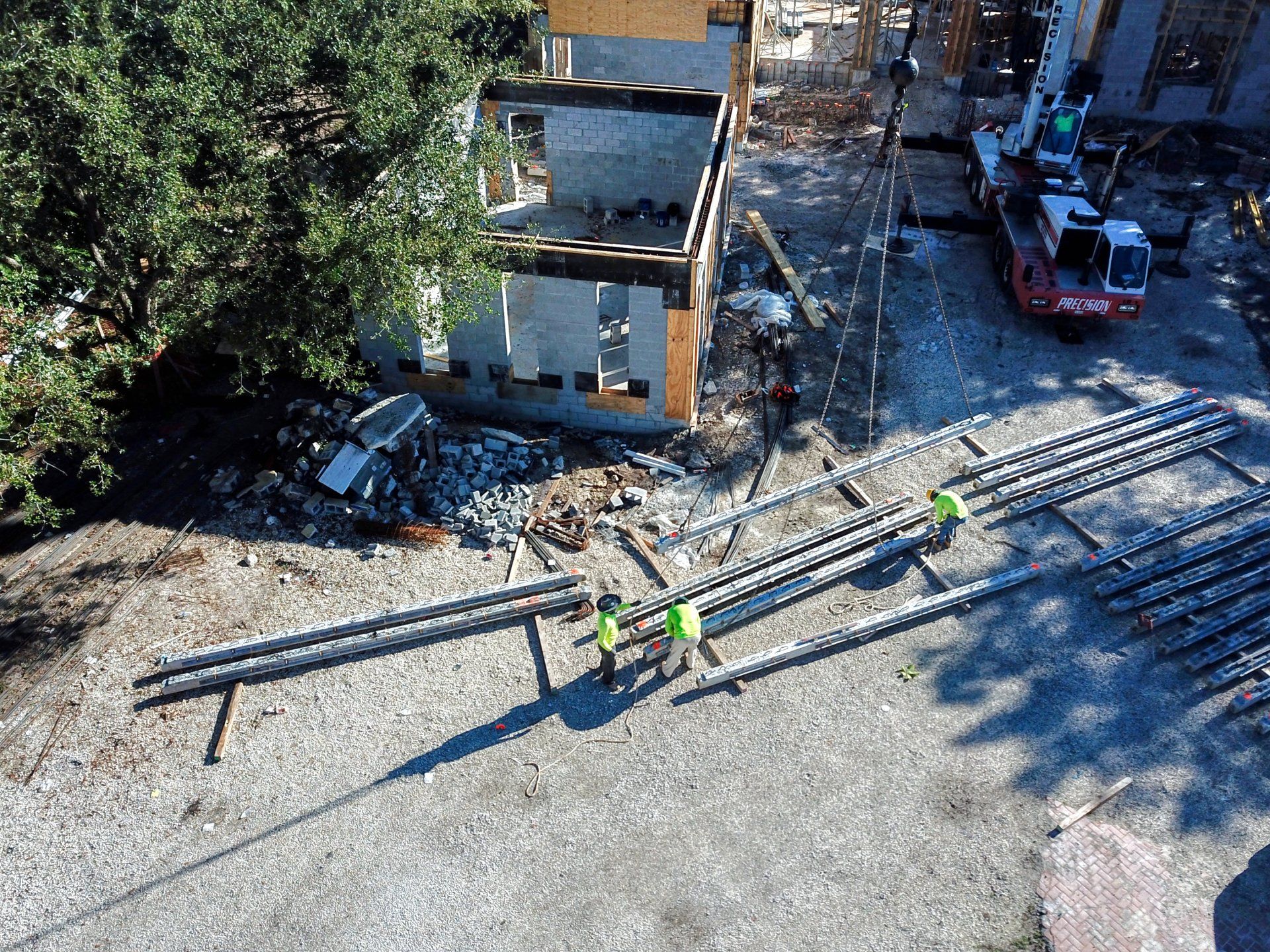 Construction site with exposed concrete and rebar. A two-story structure is partially built.