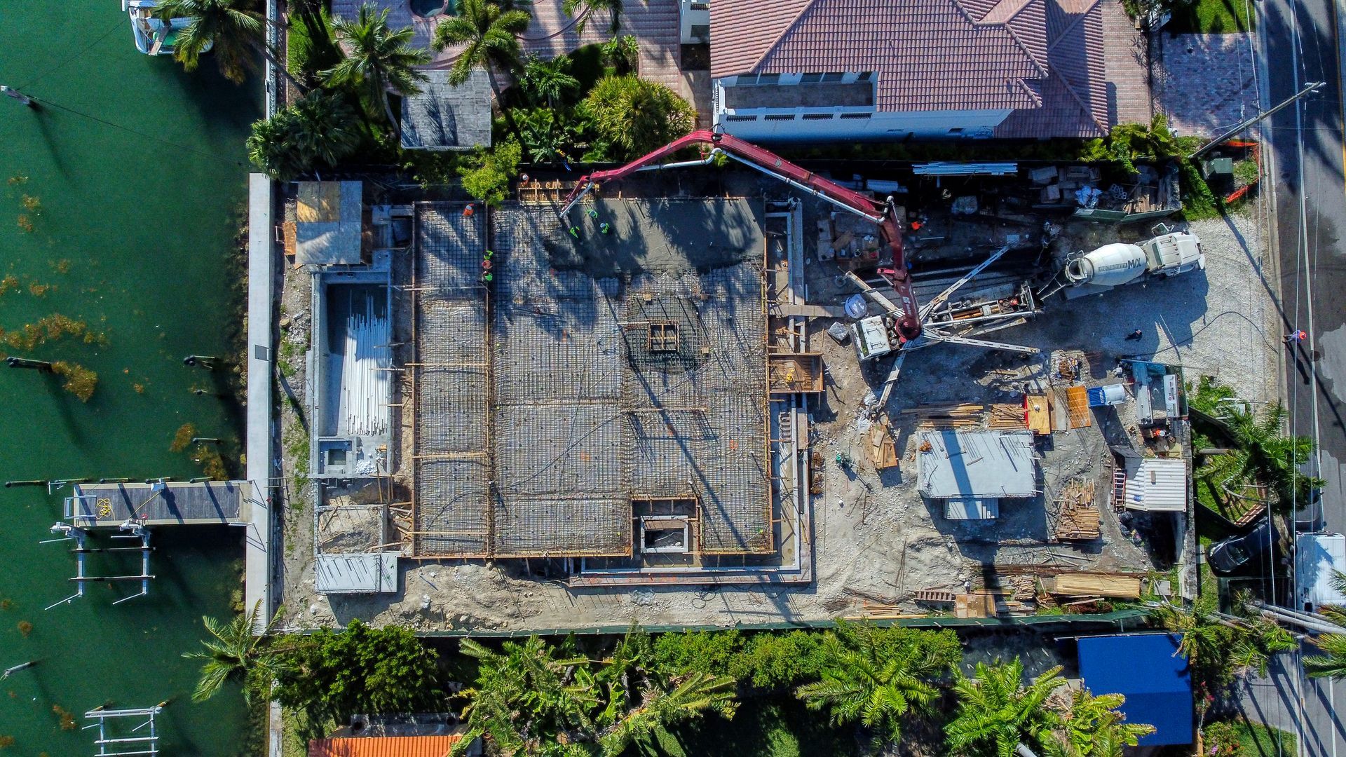 An aerial view of a building under construction next to a body of water.