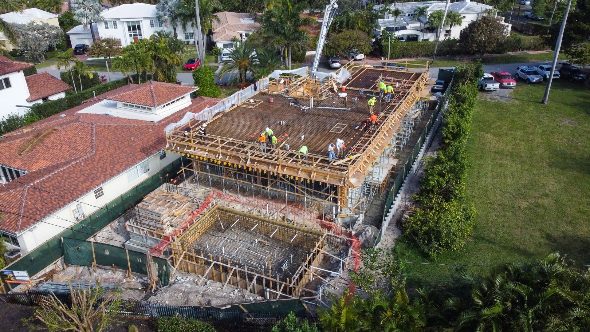 An aerial view of a building under construction in a residential area.