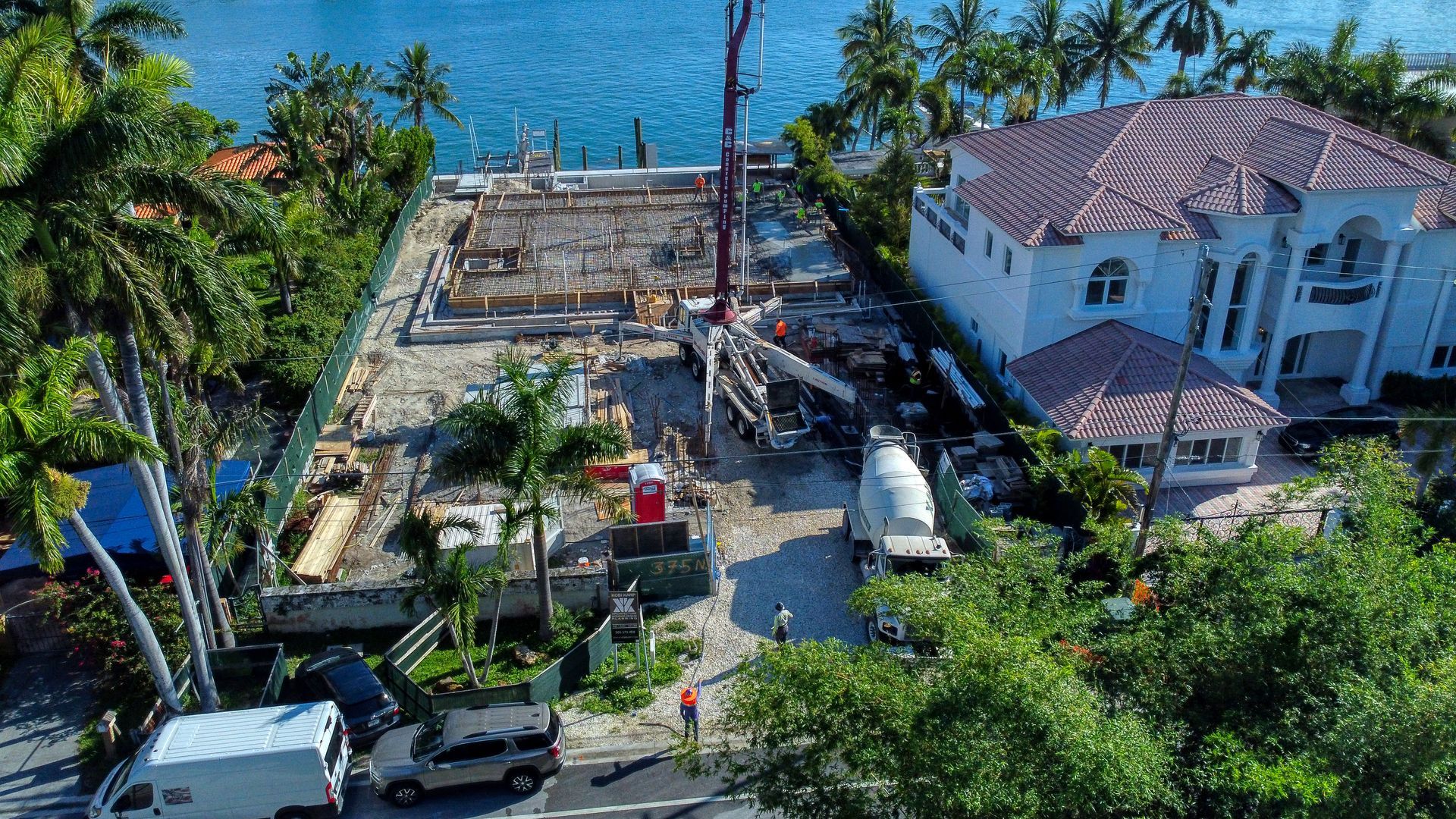 An aerial view of a house under construction next to a body of water.