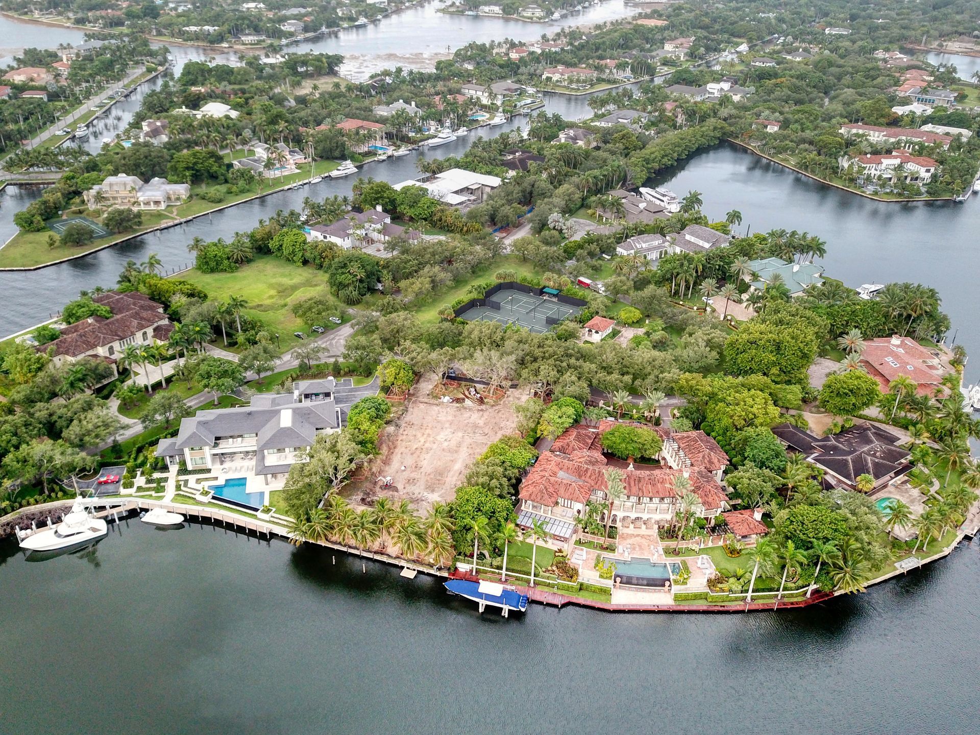 Aerial view of an island with luxury homes, waterways, and lush greenery.