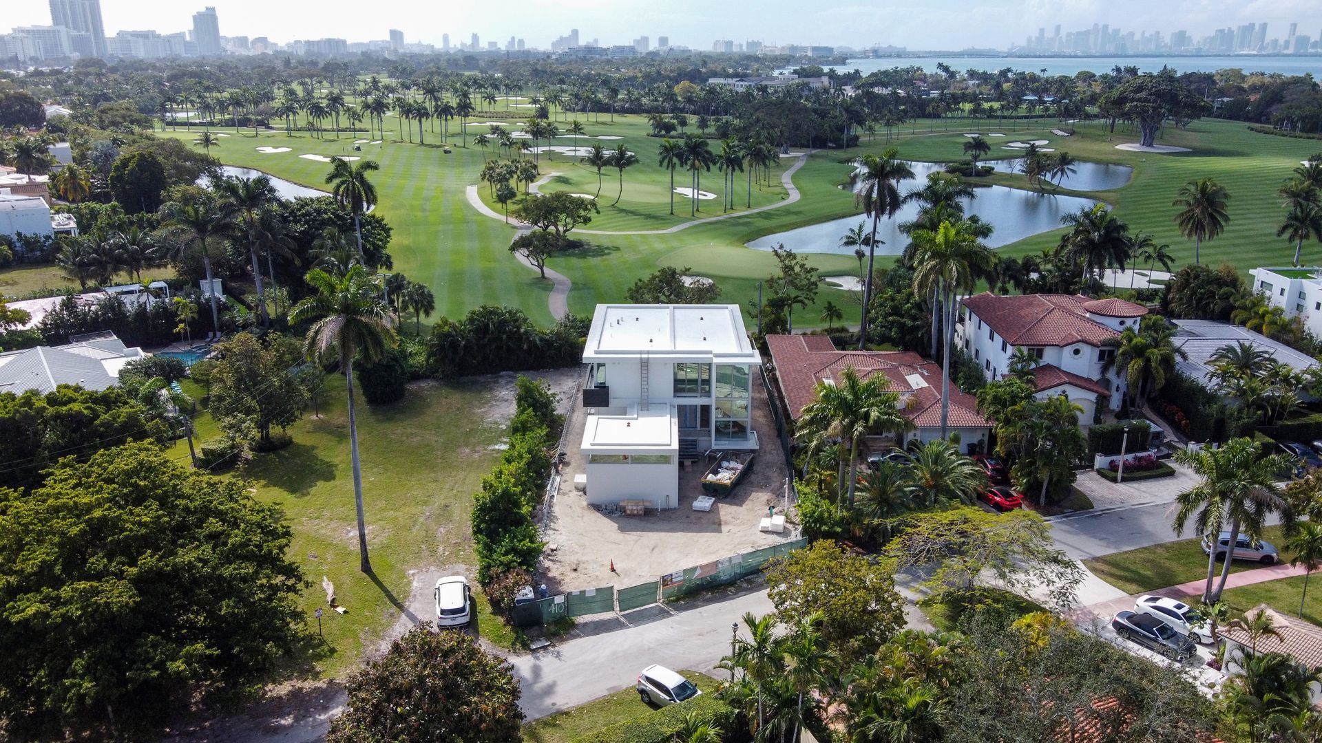 An aerial view of a house surrounded by trees and a golf course.