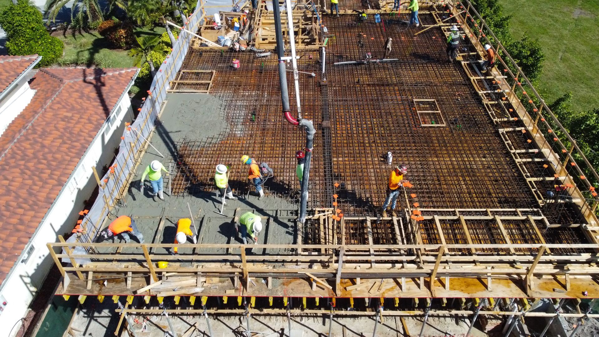 An aerial view of a construction site with workers pouring concrete.