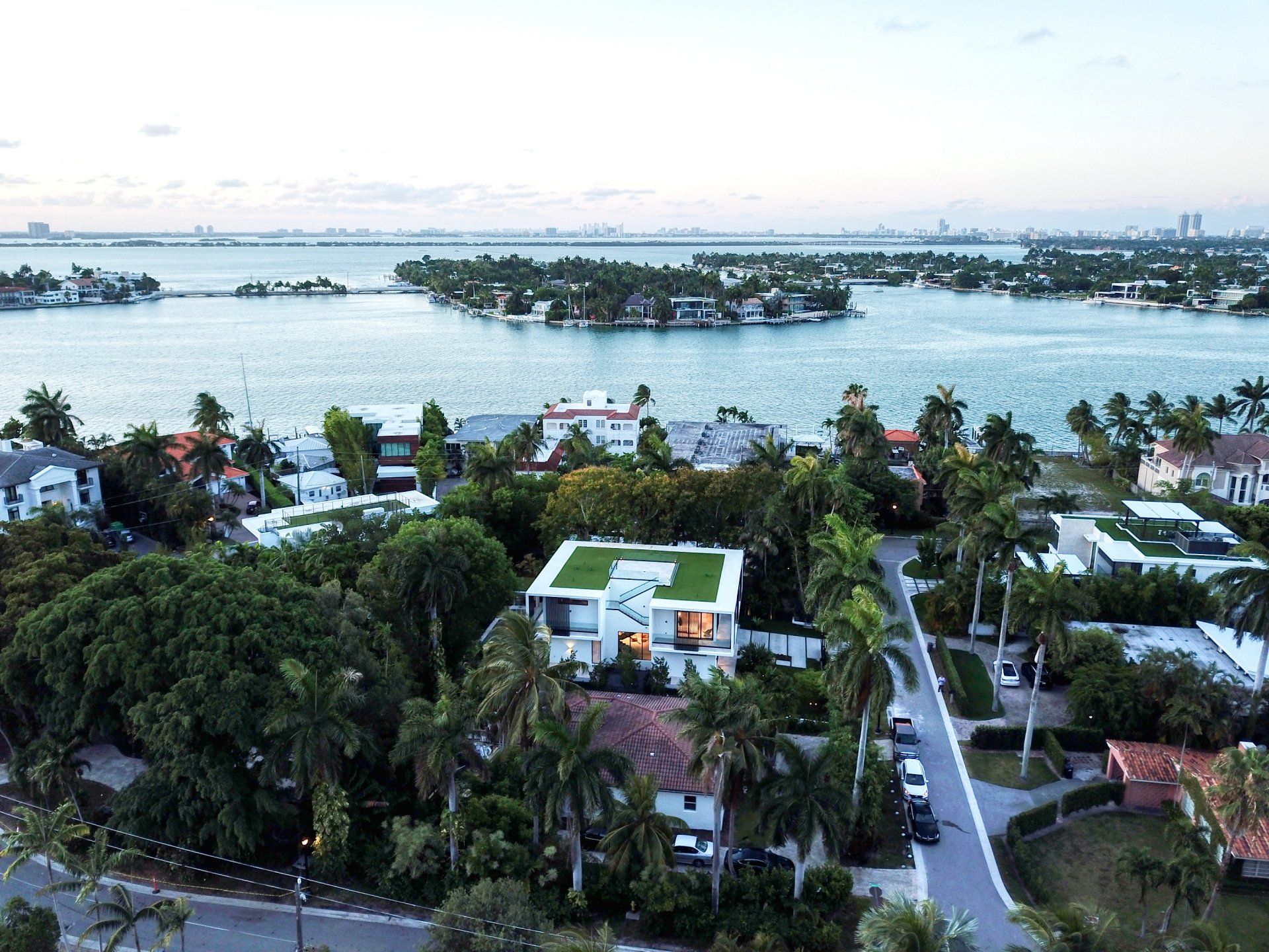 An aerial view of a house with a green roof next to a body of water.