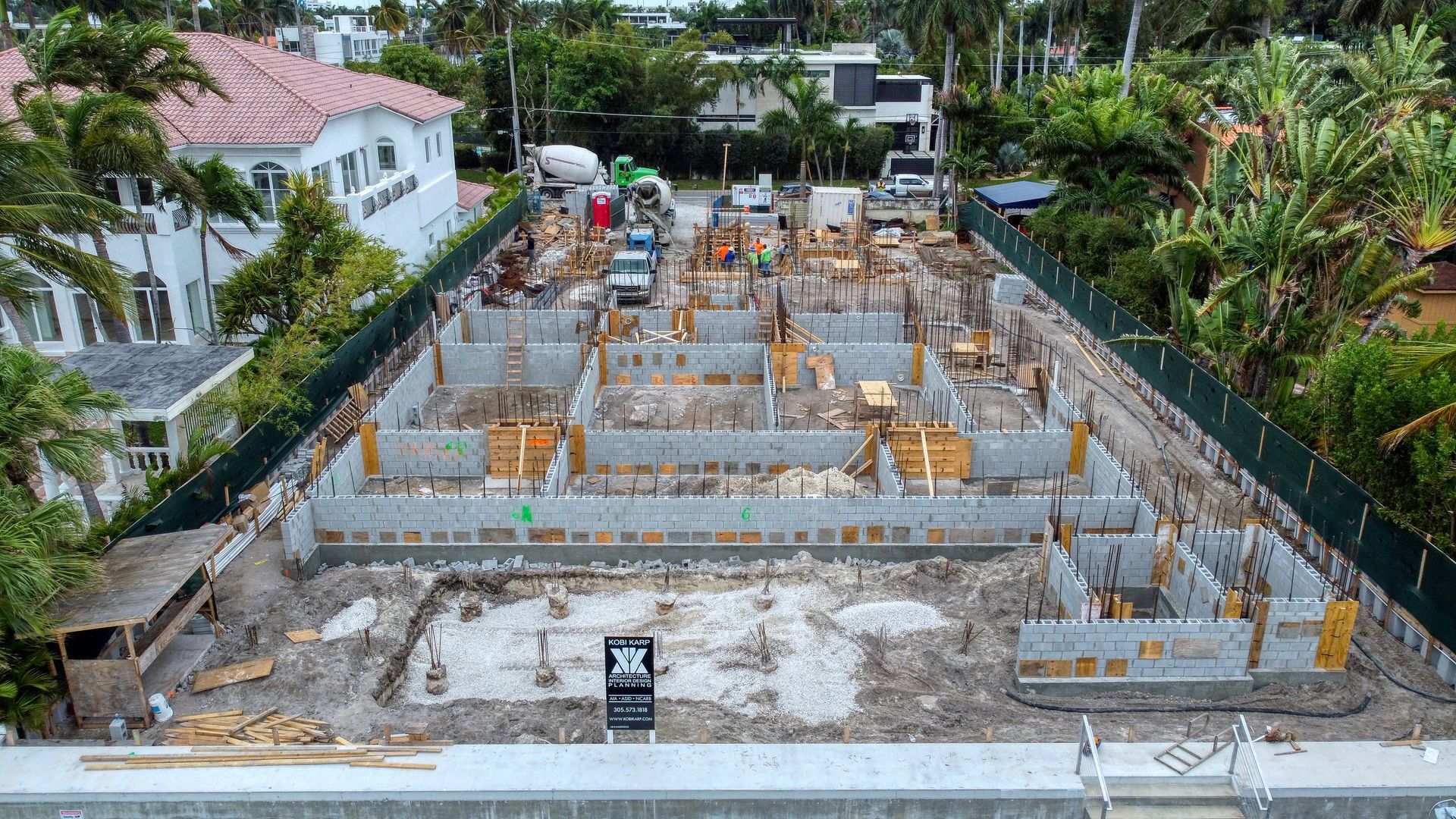 An aerial view of a building under construction in a residential area.
