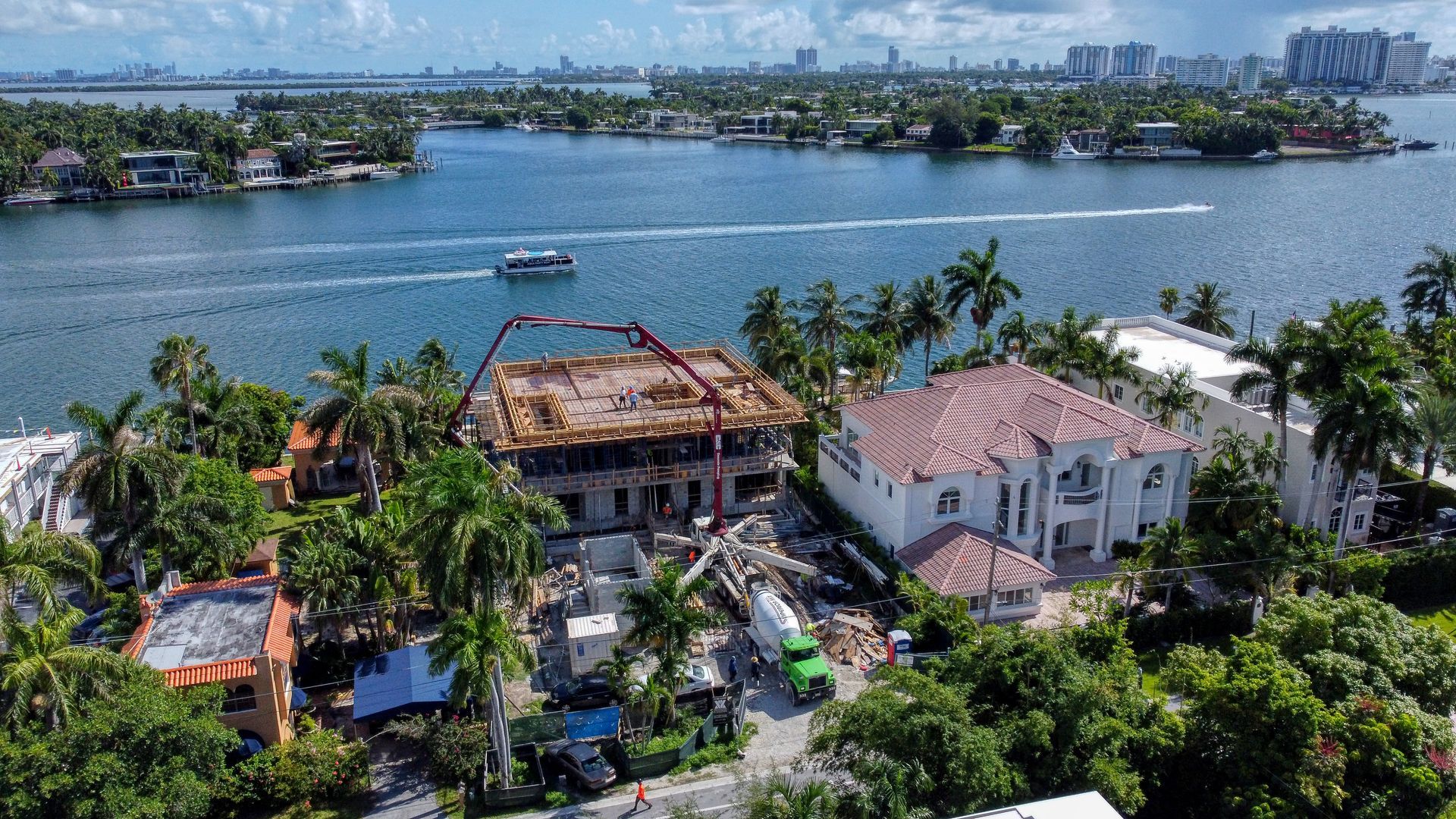 An aerial view of a building under construction next to a body of water.
