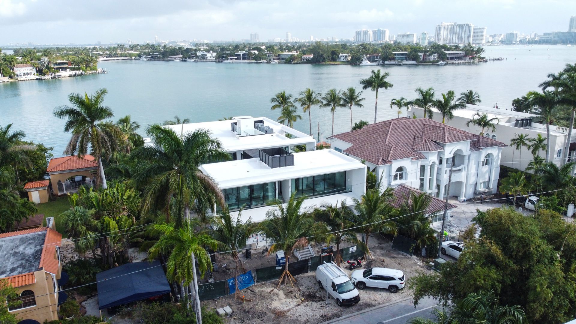 An aerial view of a large house surrounded by trees and a body of water.