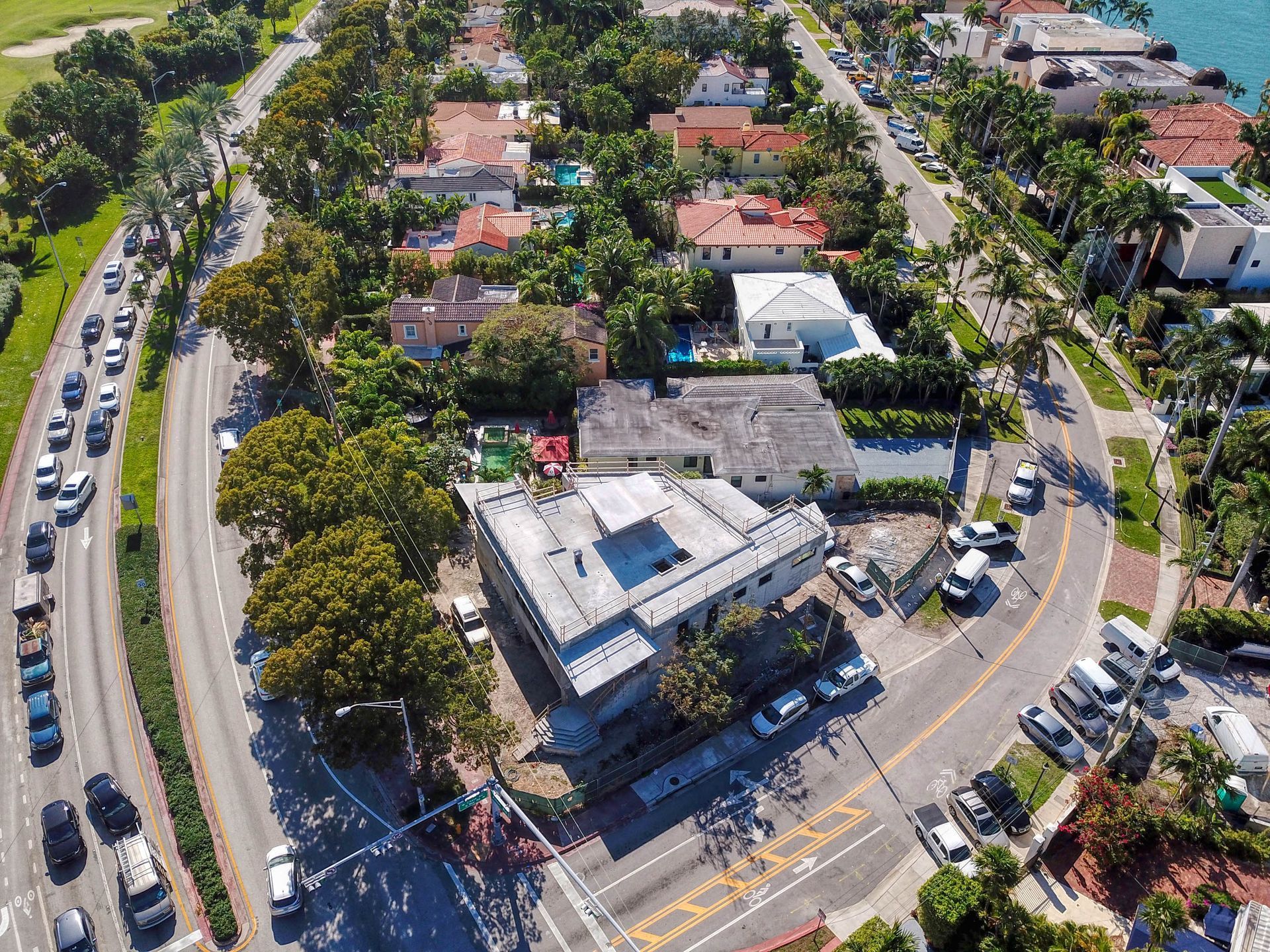 Aerial view of neighborhood streets with cars, houses, and greenery.