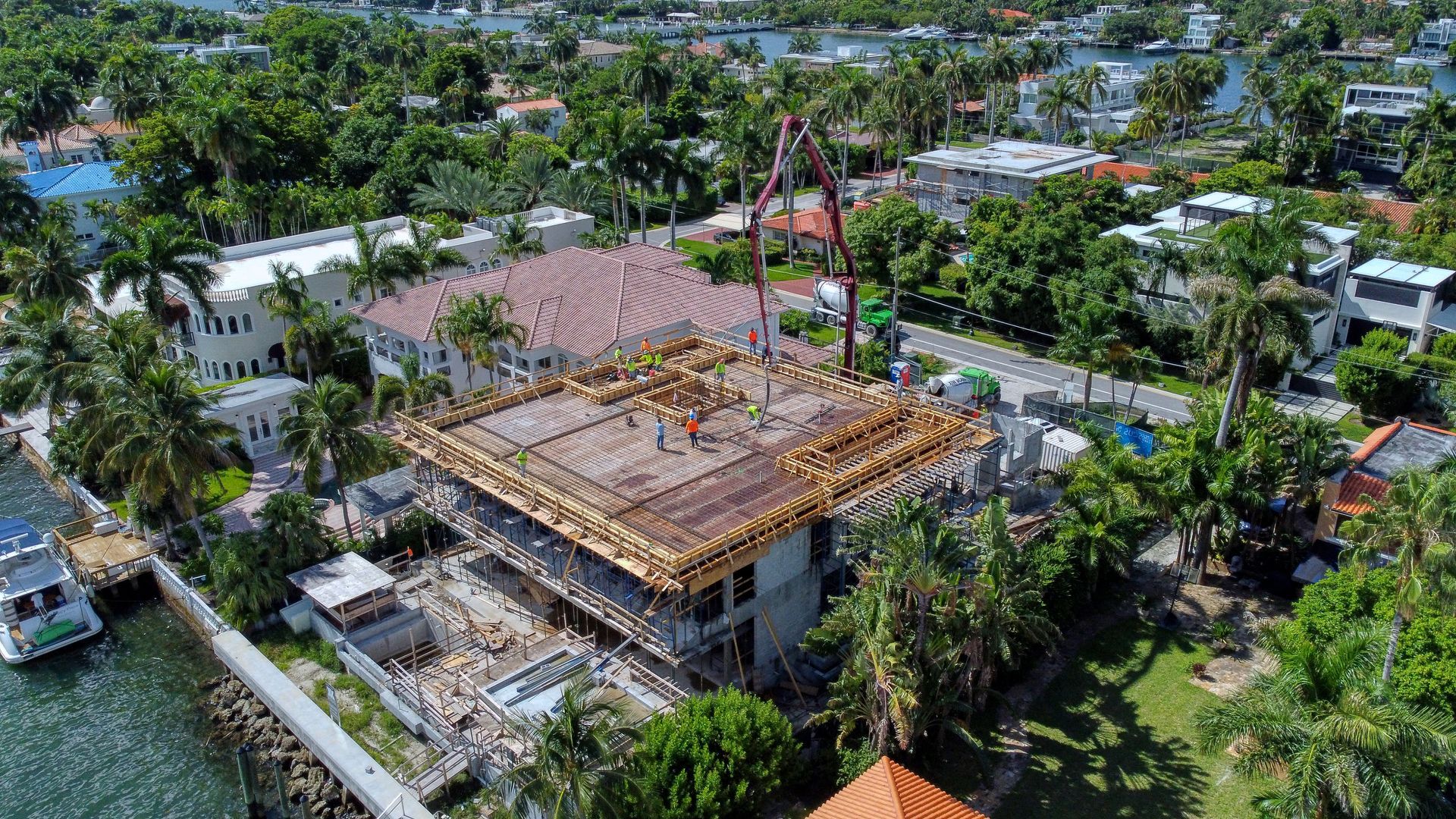 An aerial view of a building under construction next to a body of water.
