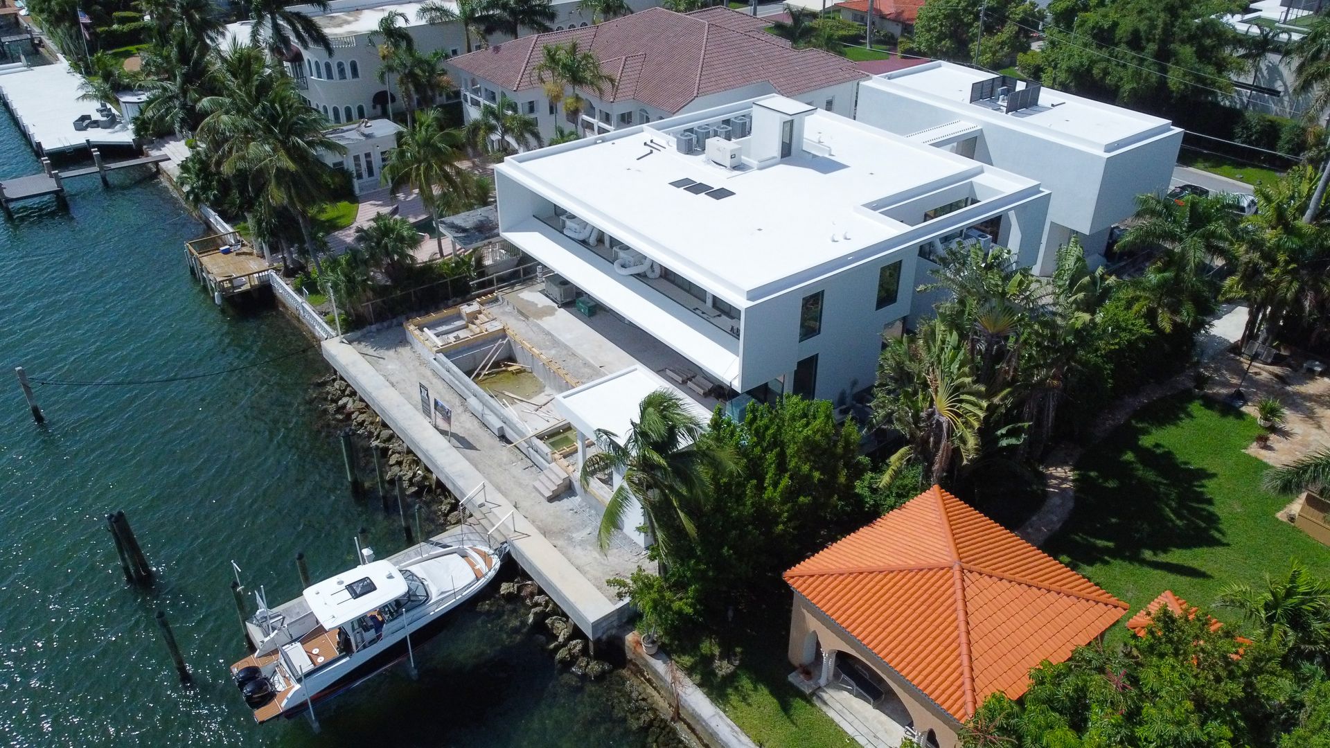 An aerial view of a large white building next to a body of water