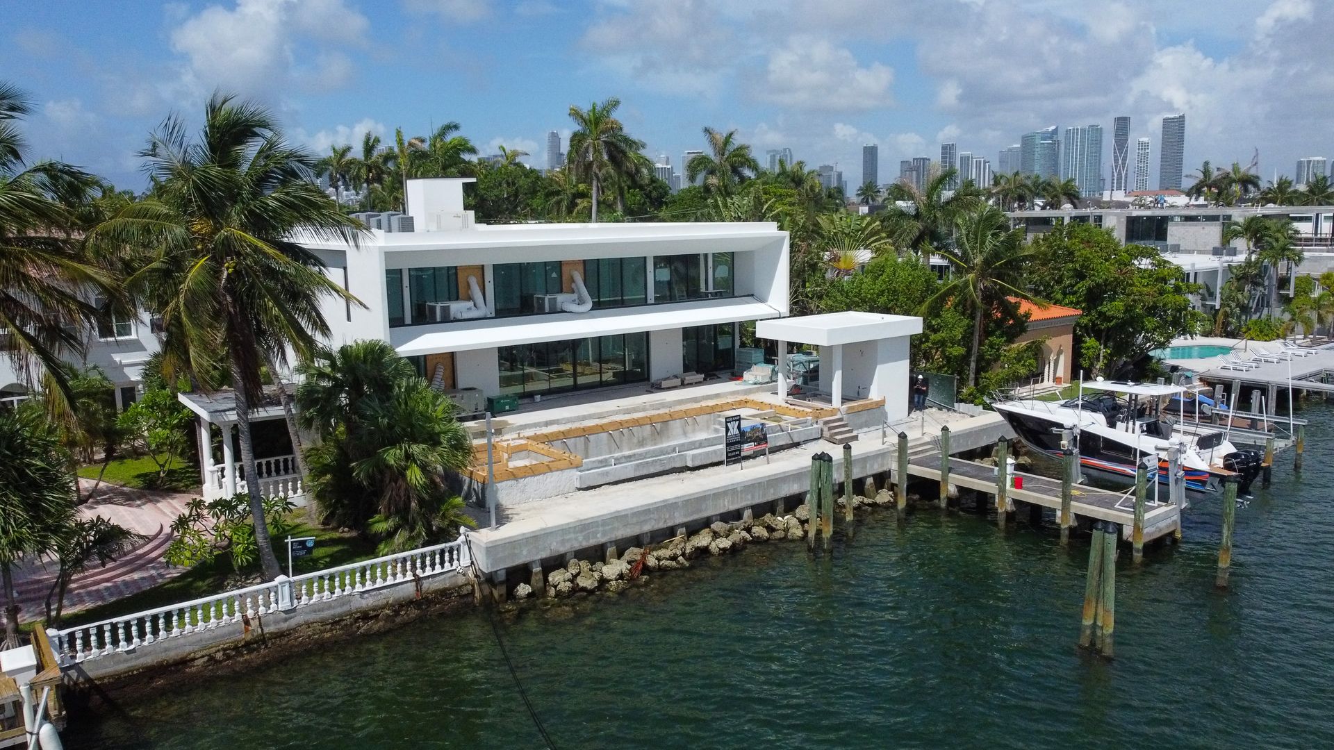 An aerial view of a large white house sitting next to a body of water.