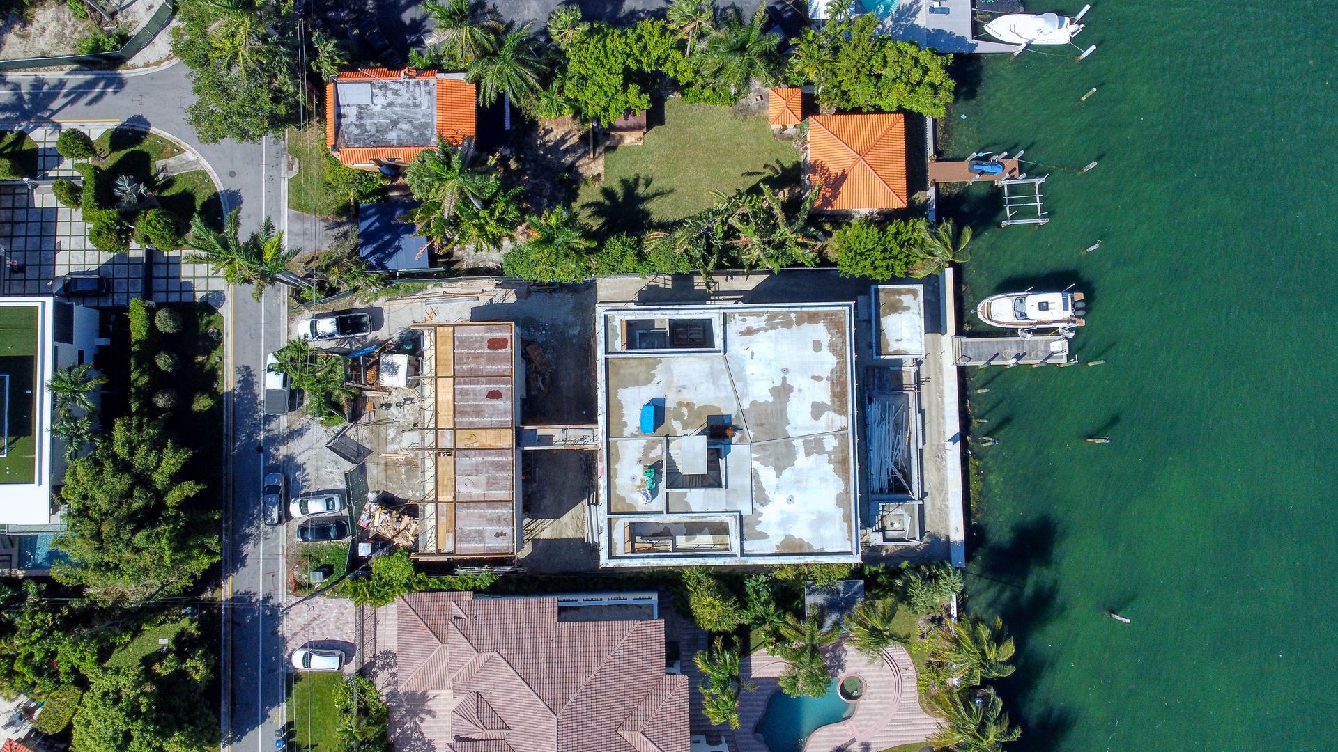 An aerial view of a house next to a body of water