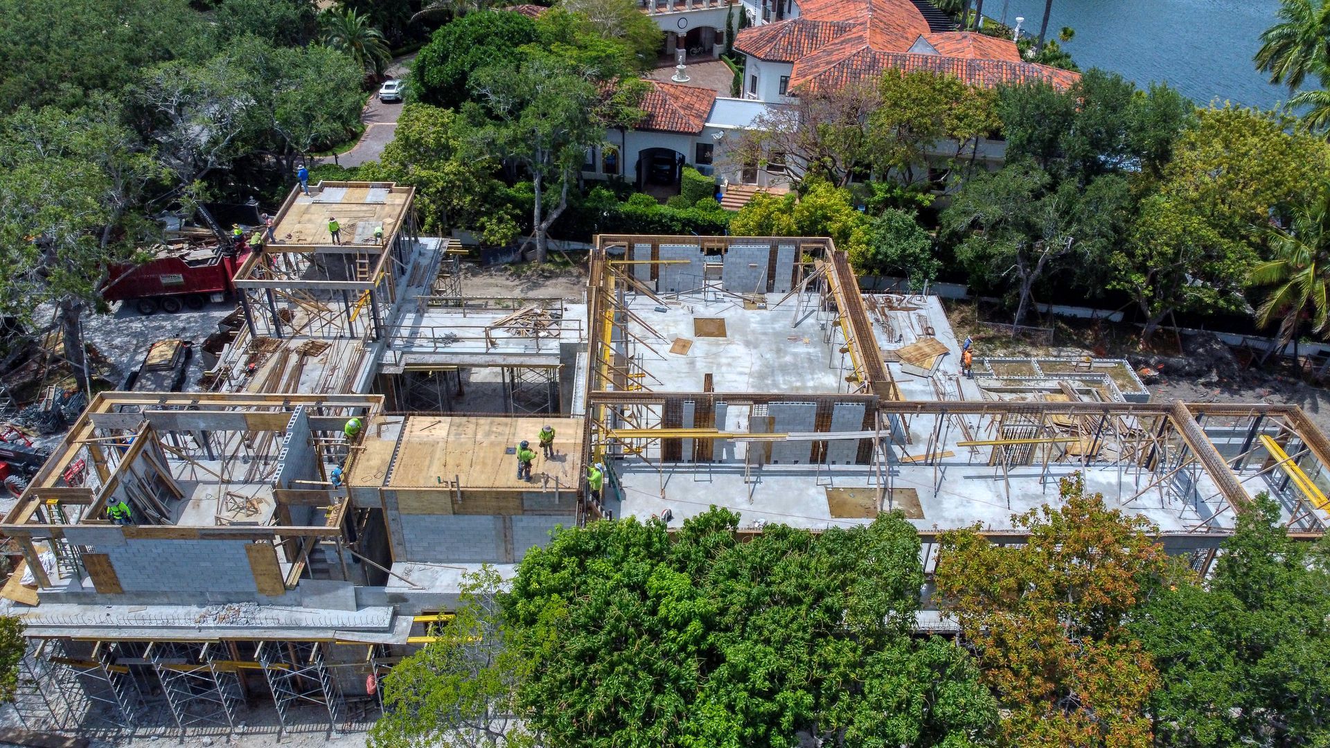 Aerial view of a multi-structure building under construction, with exposed concrete forms and wooden frameworks.