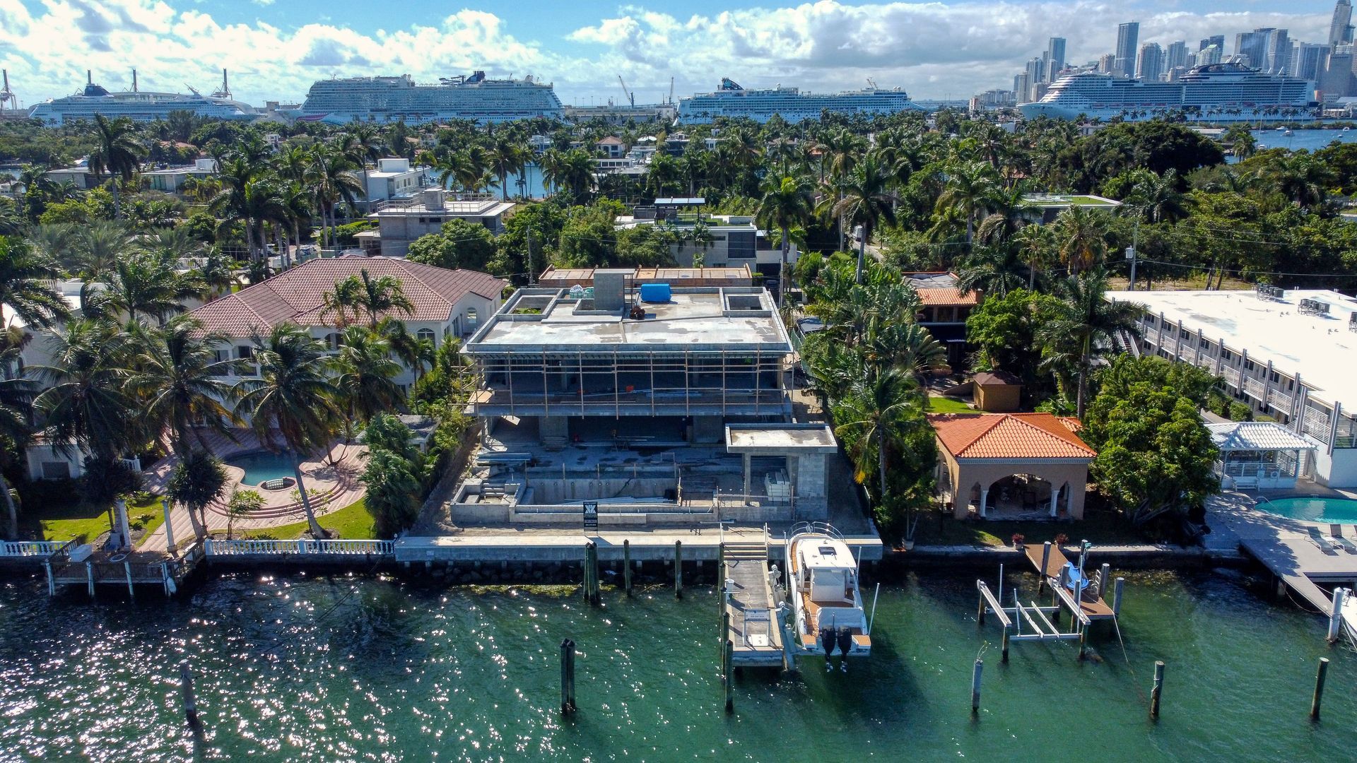 An aerial view of a large house next to a body of water.