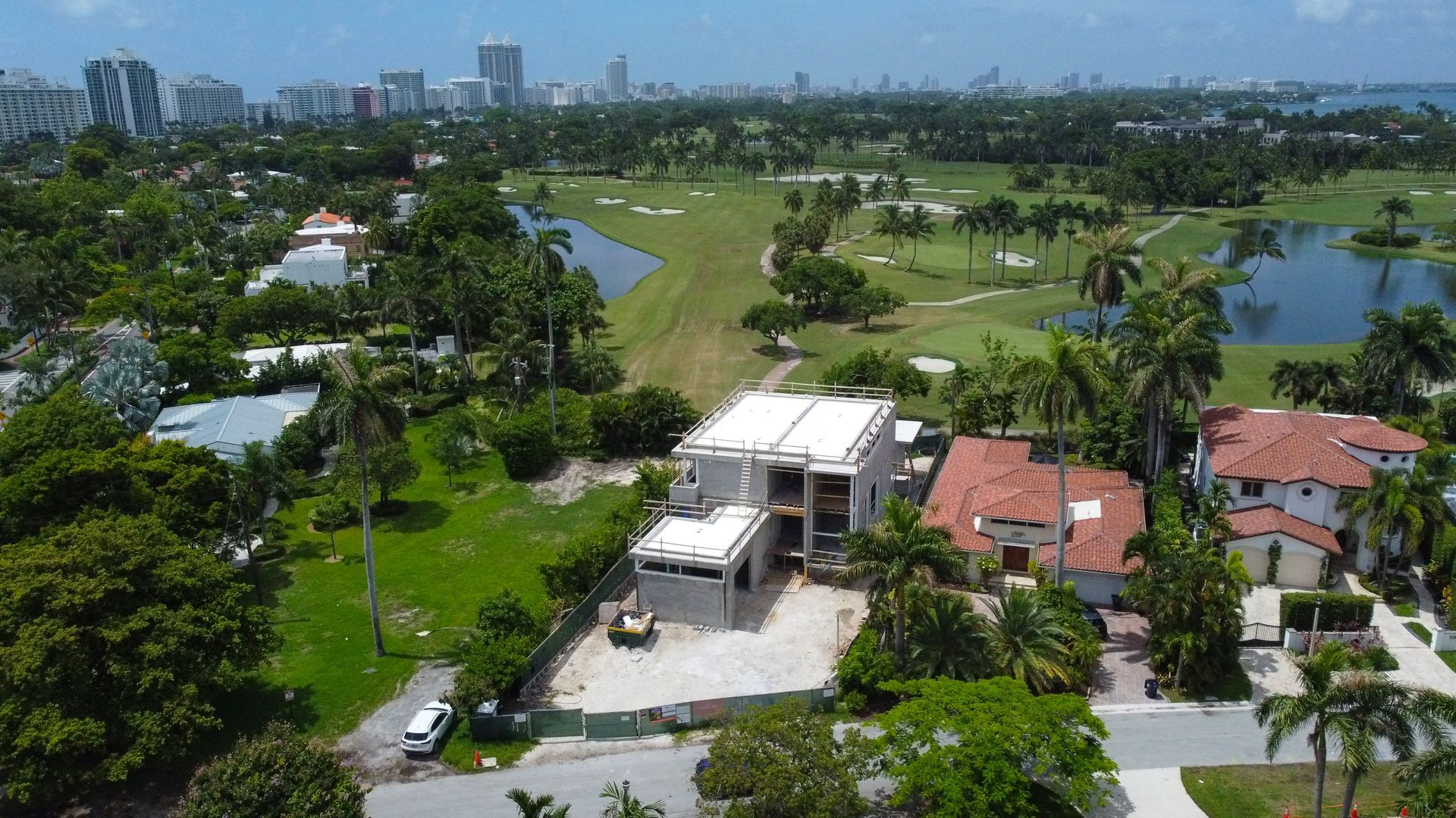 An aerial view of a residential area with a golf course in the background