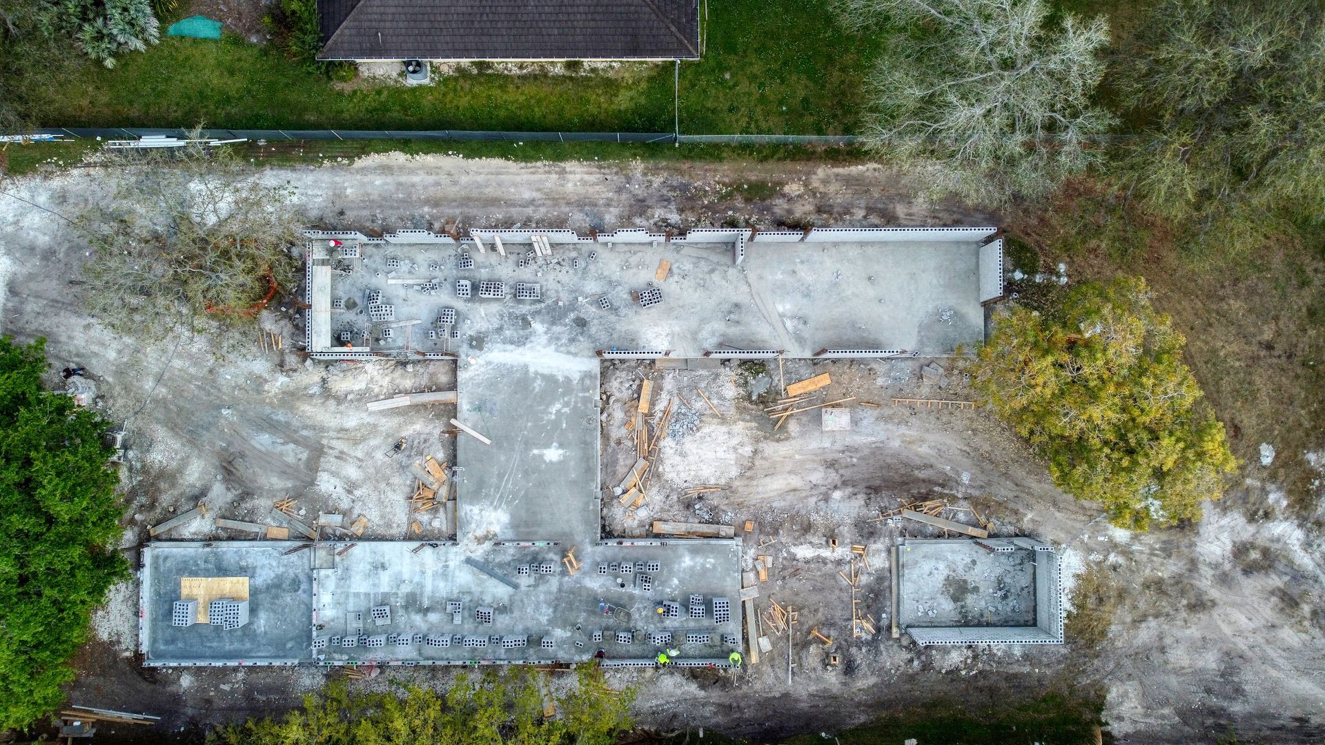 Overhead view of a building in the process of demolition, with exposed foundation and debris.