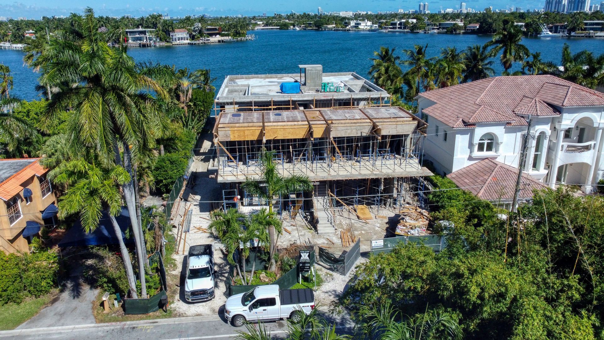 An aerial view of a building under construction next to a body of water.