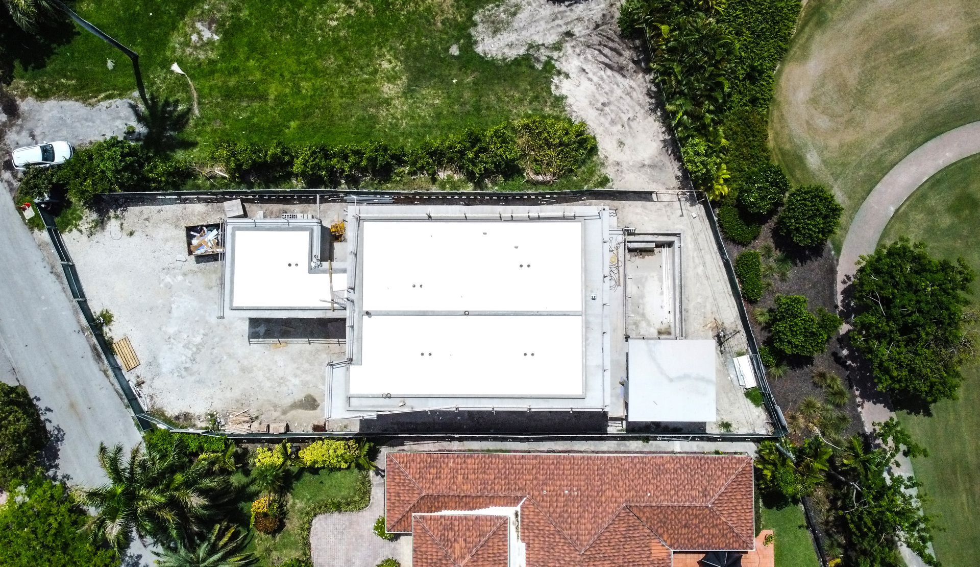 An aerial view of a house with a lot of trees in the background.