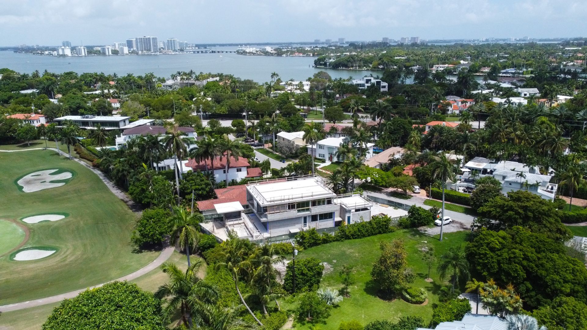 An aerial view of a residential area with a golf course in the background.