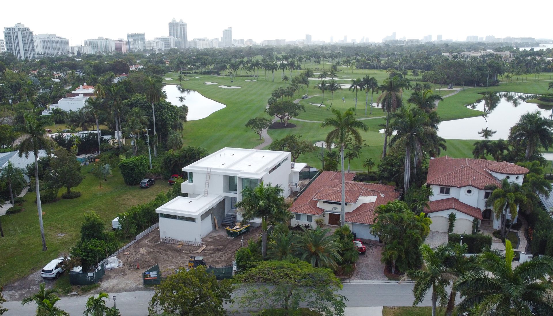 An aerial view of a house with a golf course in the background