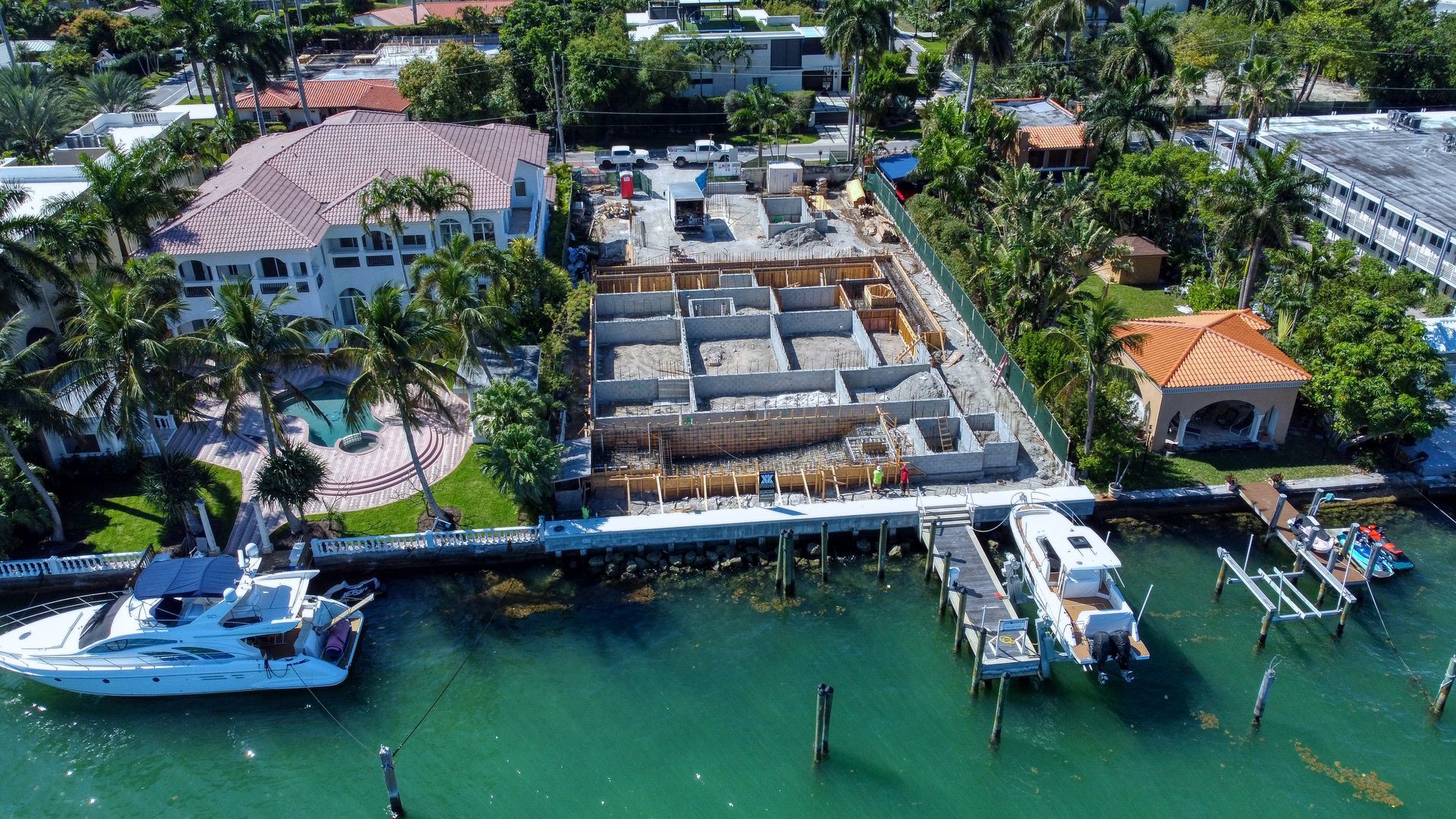 An aerial view of a building under construction next to a body of water.
