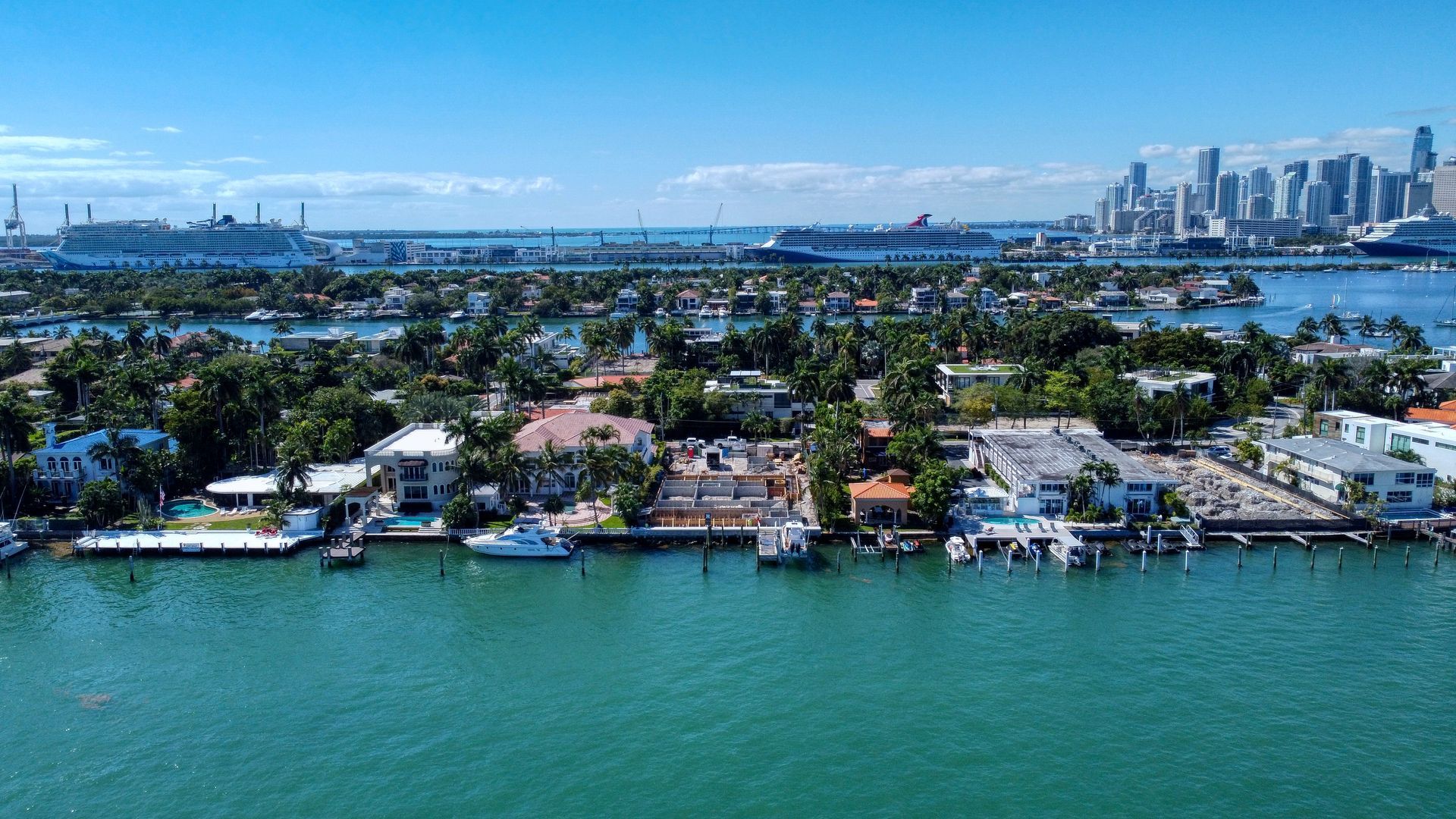 An aerial view of a residential area next to a body of water with a city in the background.