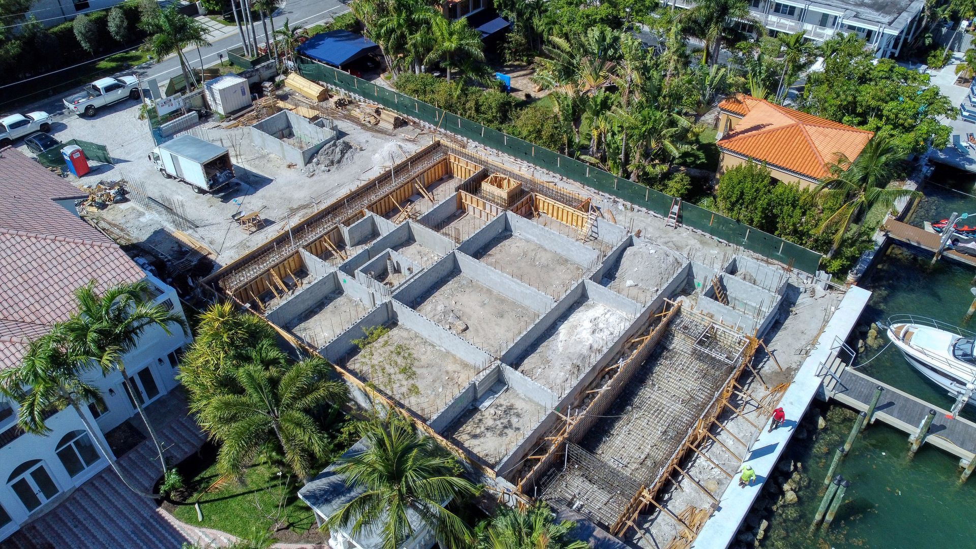 An aerial view of a building under construction next to a body of water.
