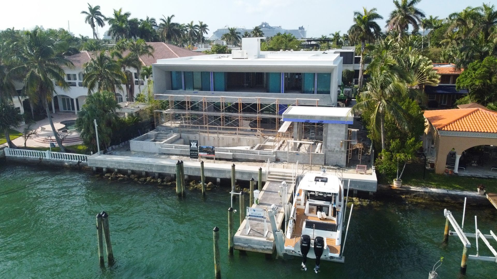 A boat is docked in front of a large house