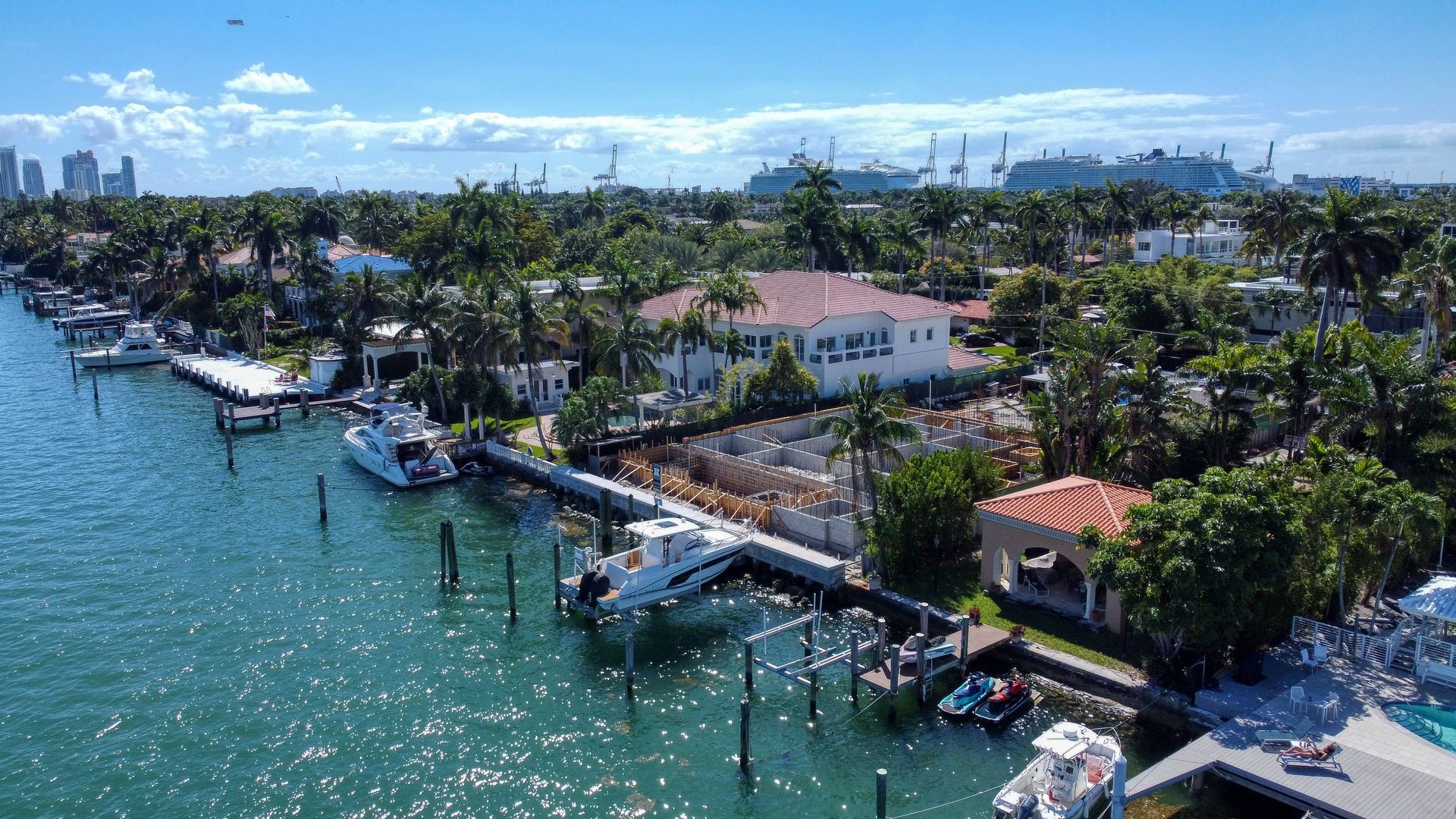 An aerial view of a residential area with boats docked in a harbor.