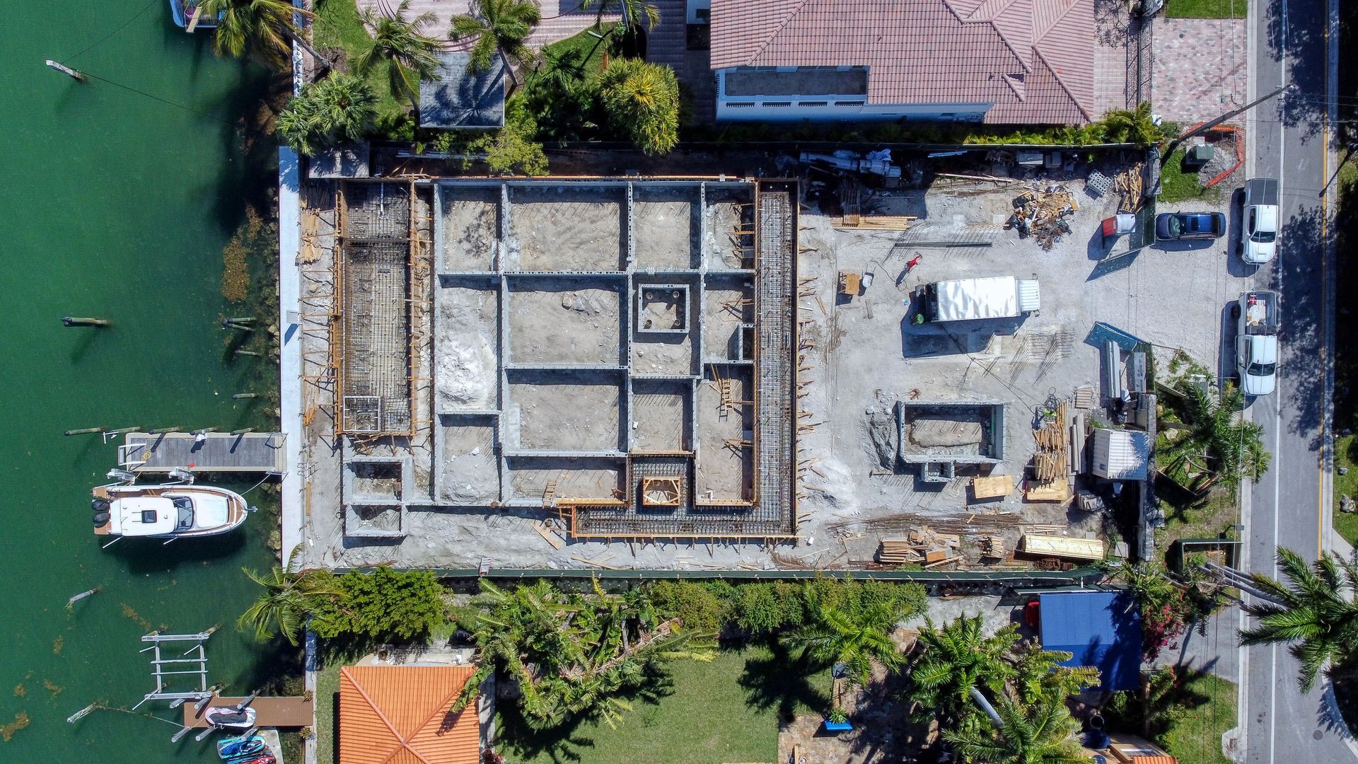 An aerial view of a house under construction next to a body of water.