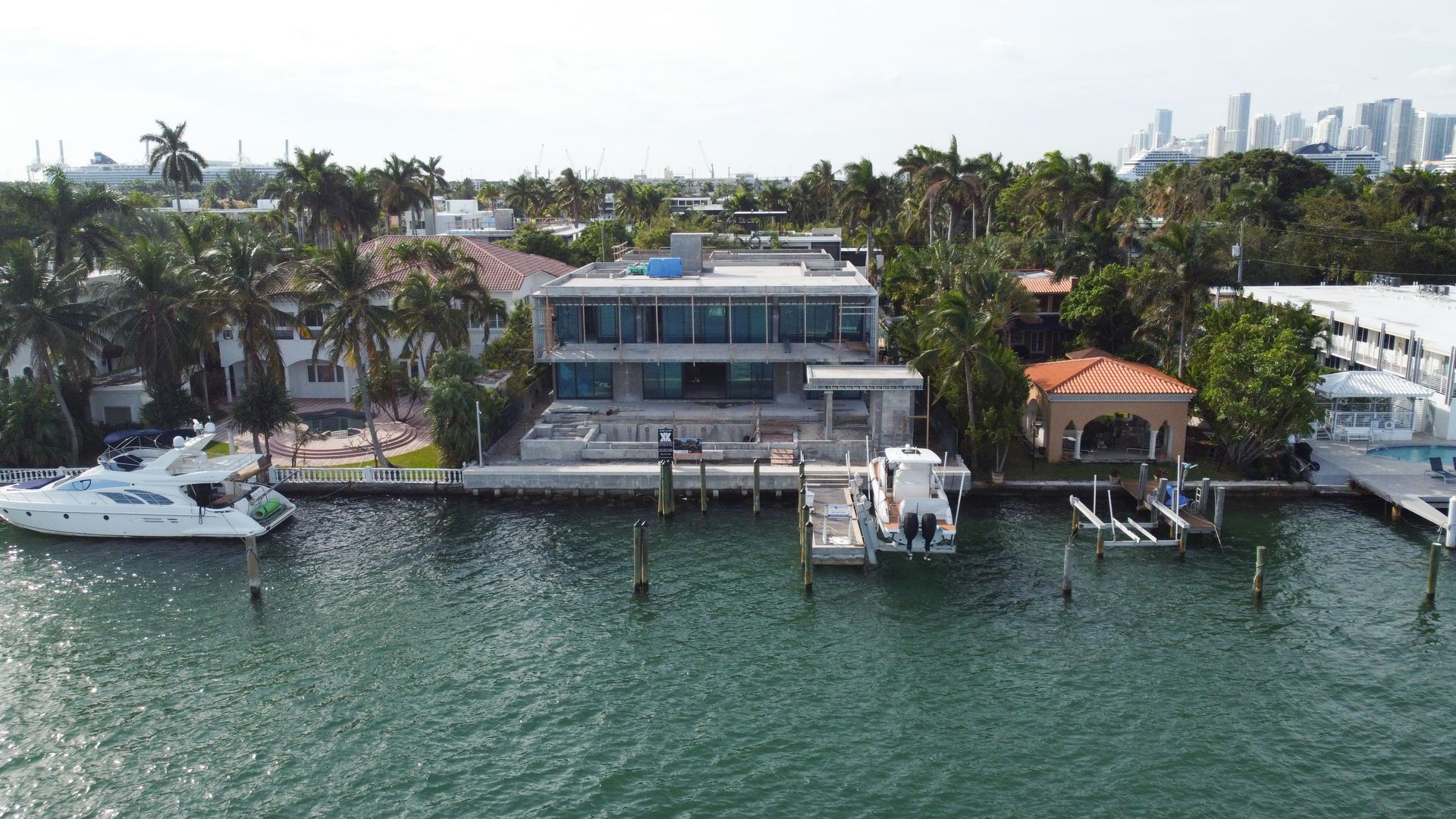 An aerial view of a large house sitting on top of a body of water.