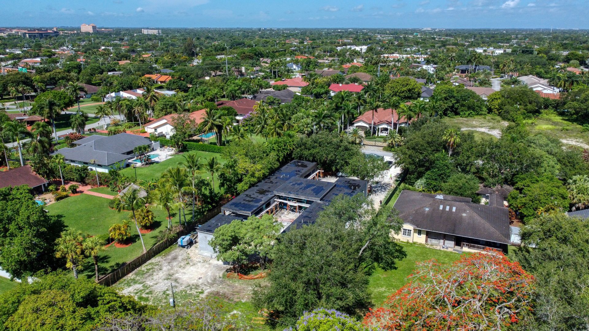 Aerial view of a suburban neighborhood with houses, trees, and construction.
