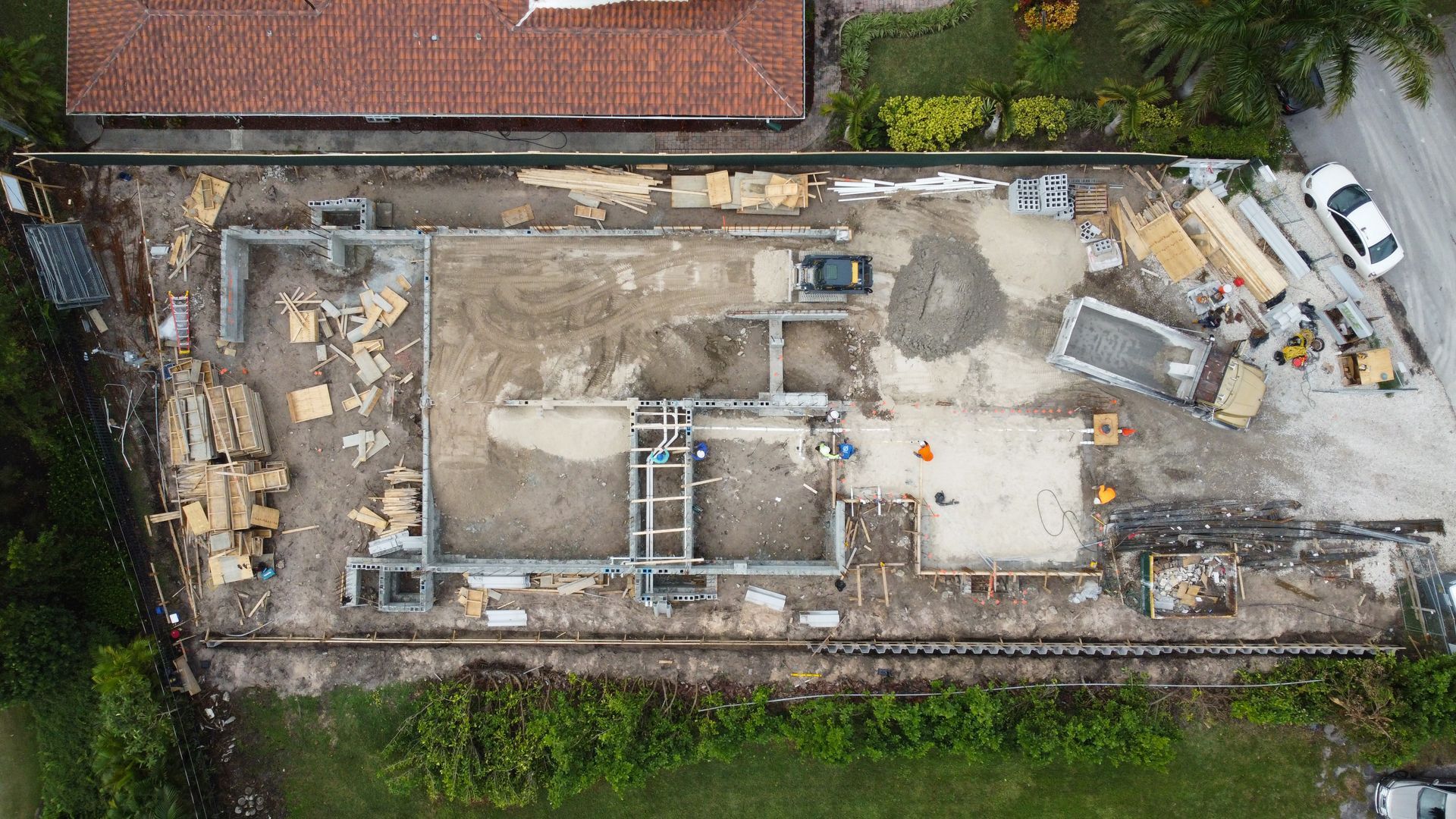 An aerial view of a construction site with a house in the background.