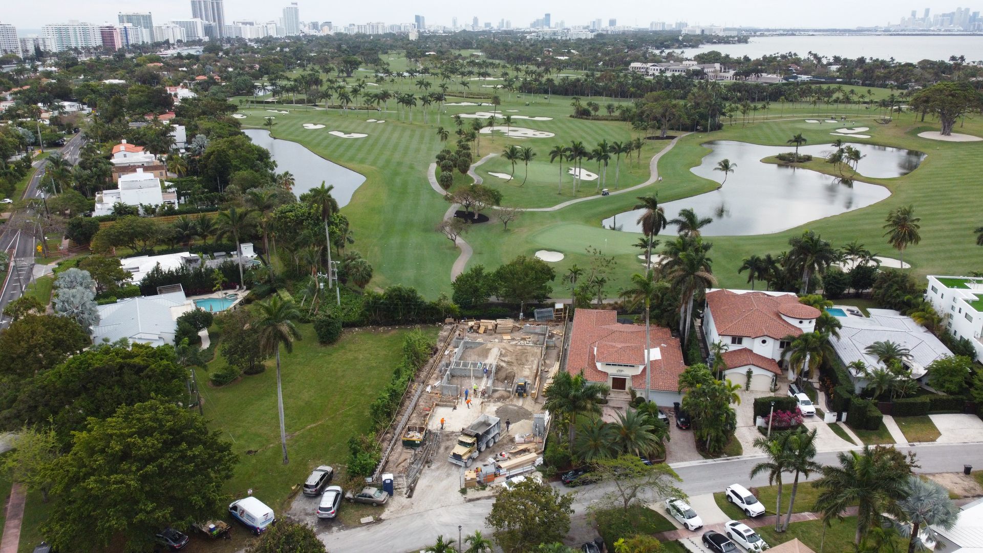 An aerial view of a golf course surrounded by houses and trees.