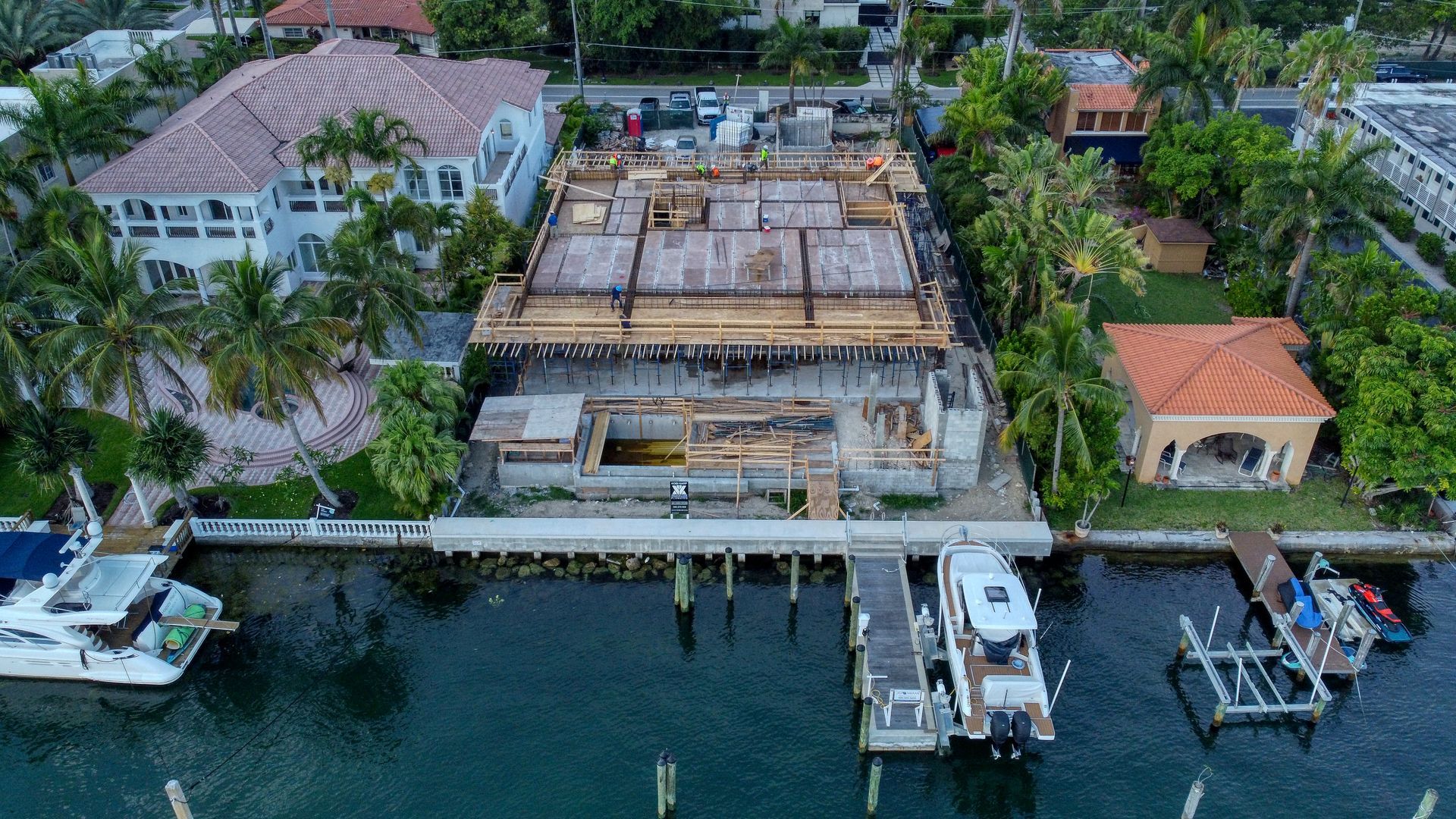 An aerial view of a building under construction next to a body of water