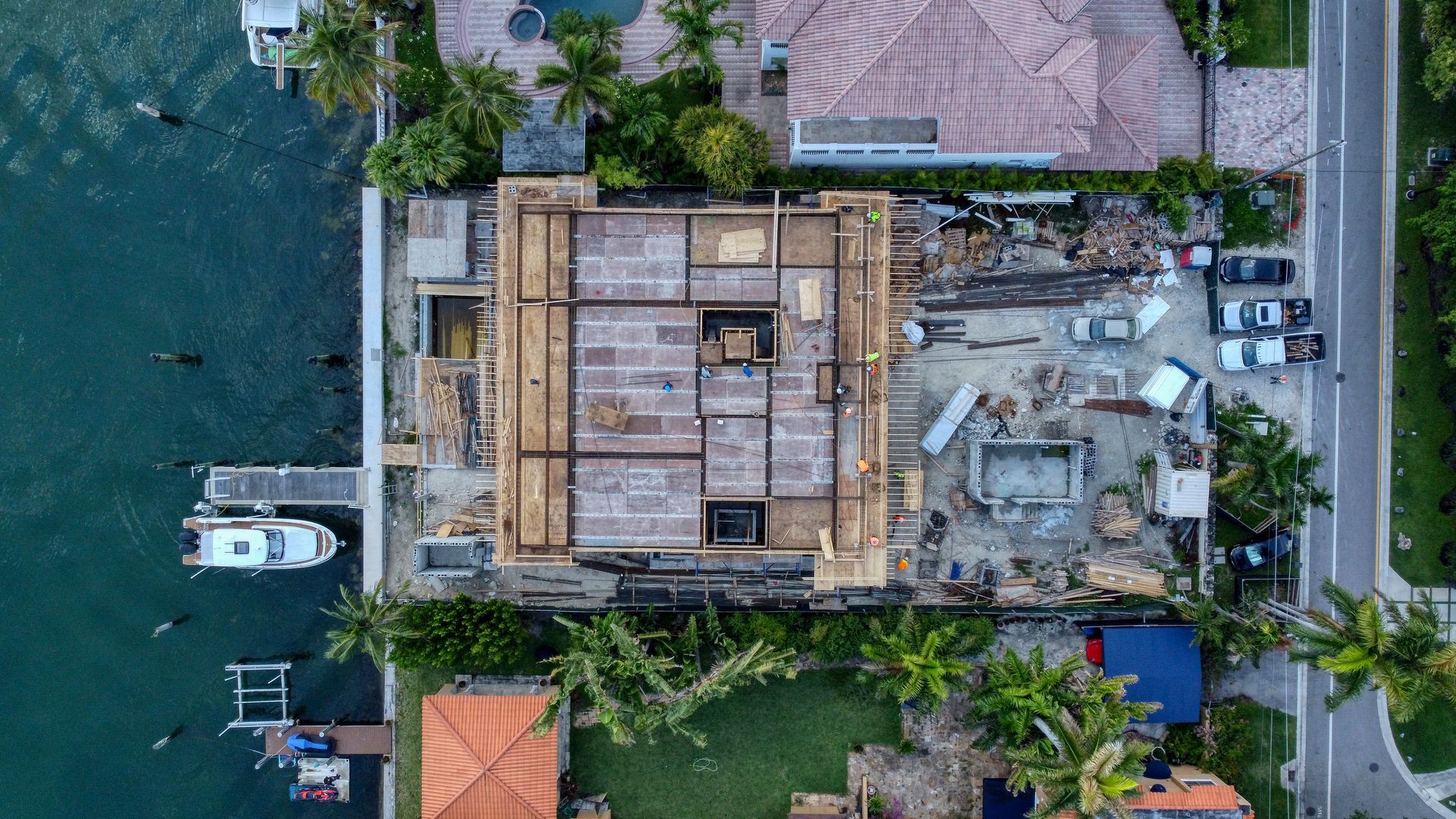 An aerial view of a house under construction next to a body of water.