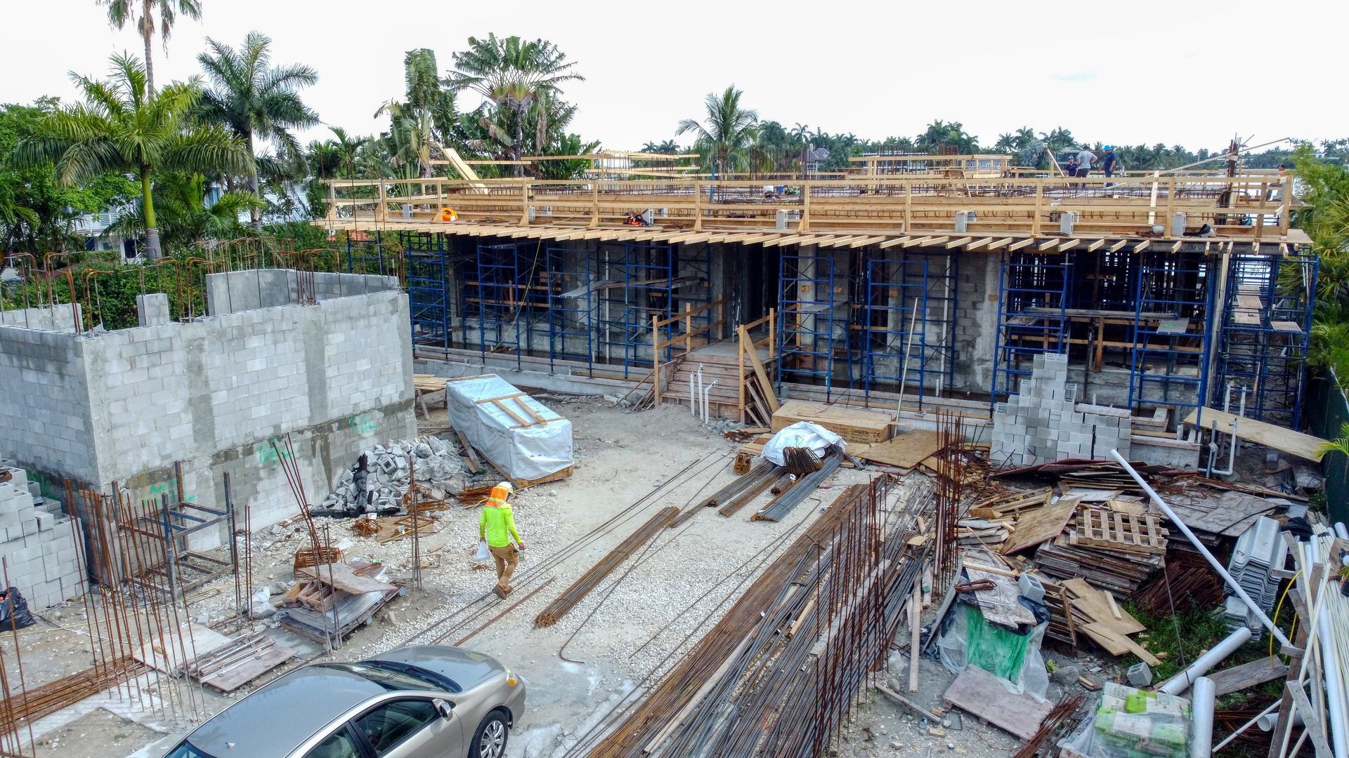 An aerial view of a construction site with a car parked in front of it.