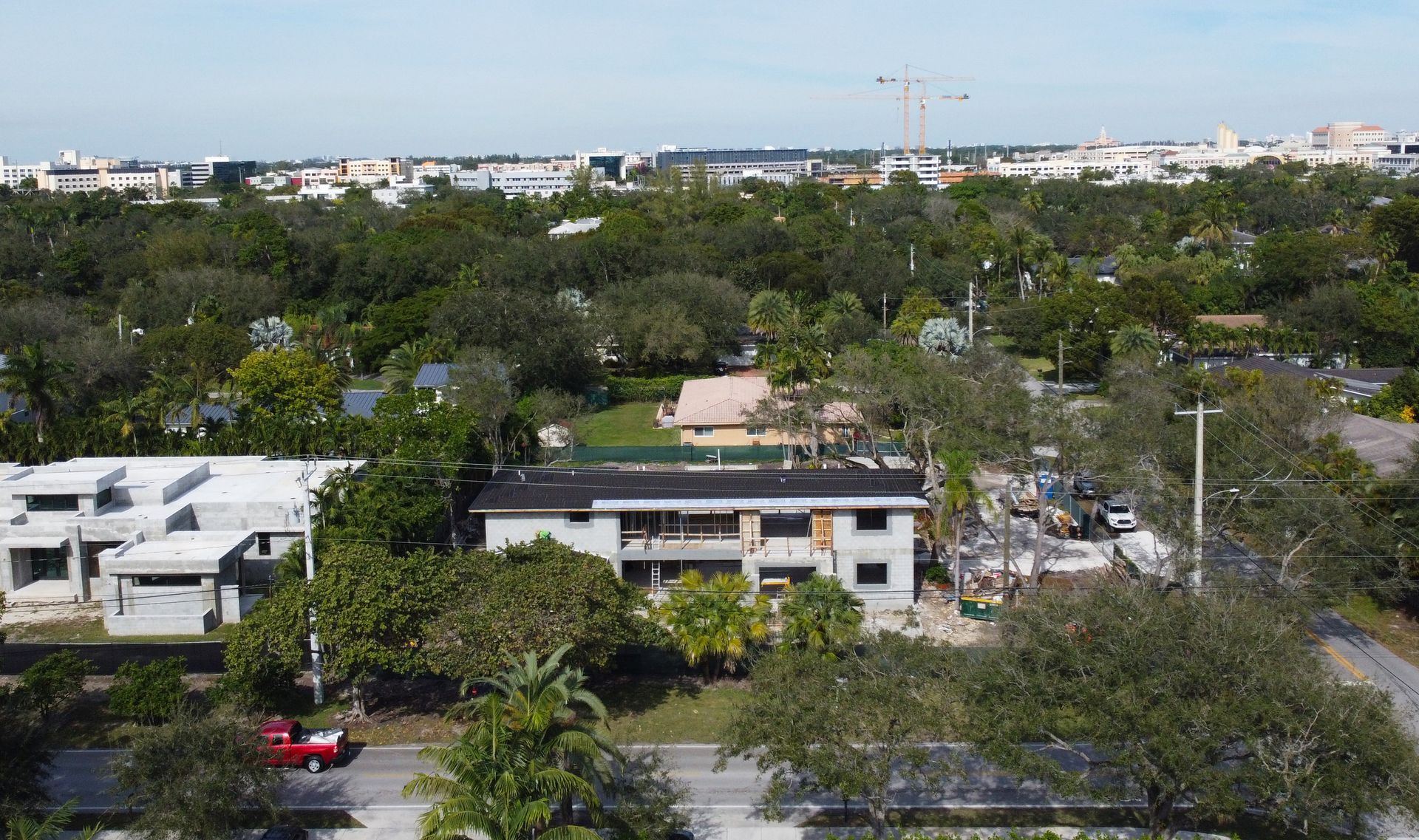 Aerial view of neighborhood with buildings, construction, and trees.
