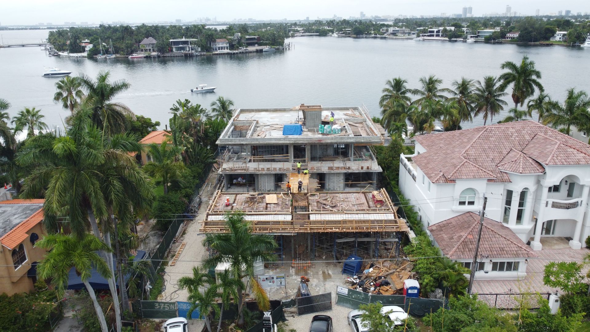 An aerial view of a house under construction next to a body of water.