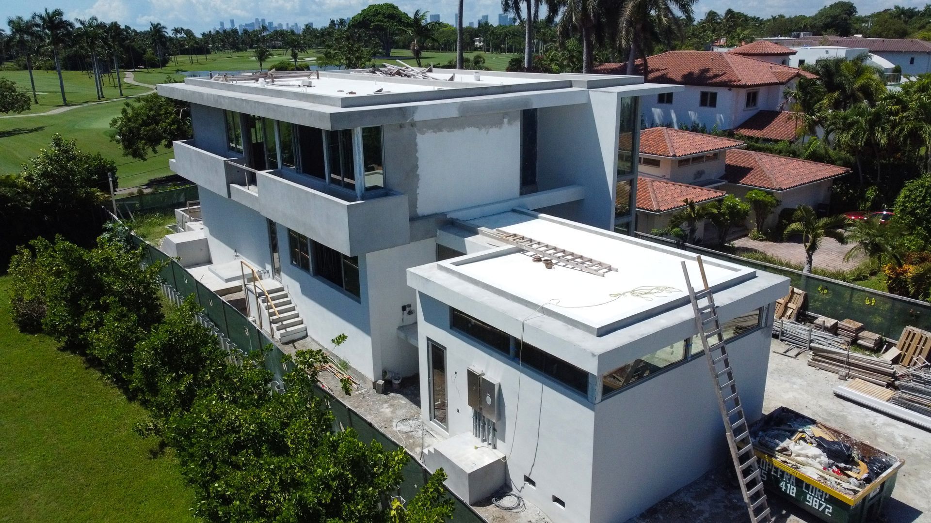 An aerial view of a large white house under construction