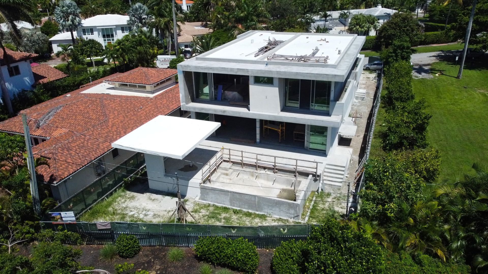 An aerial view of a large house under construction in a residential area.
