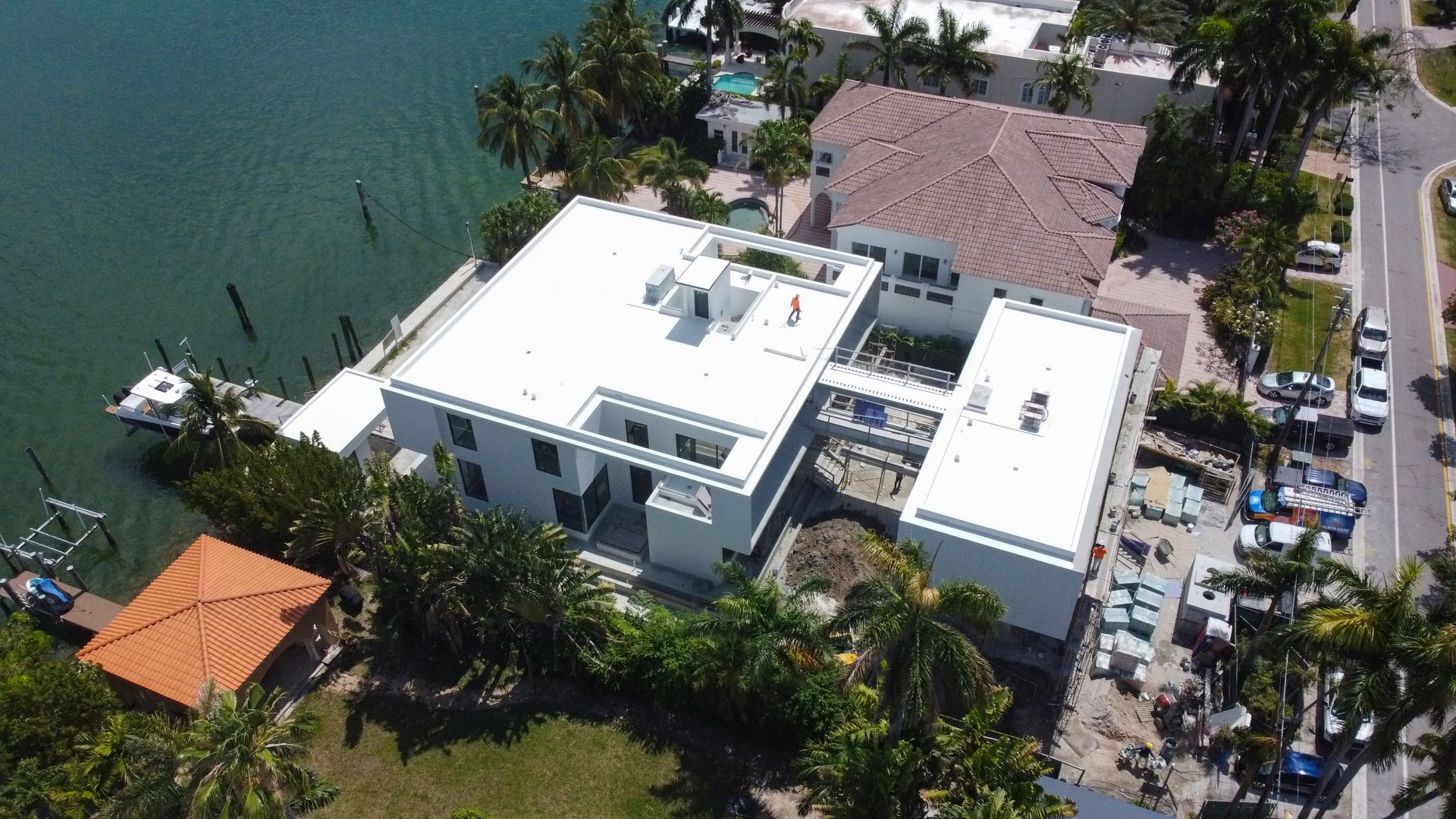 An aerial view of a large white building next to a body of water.