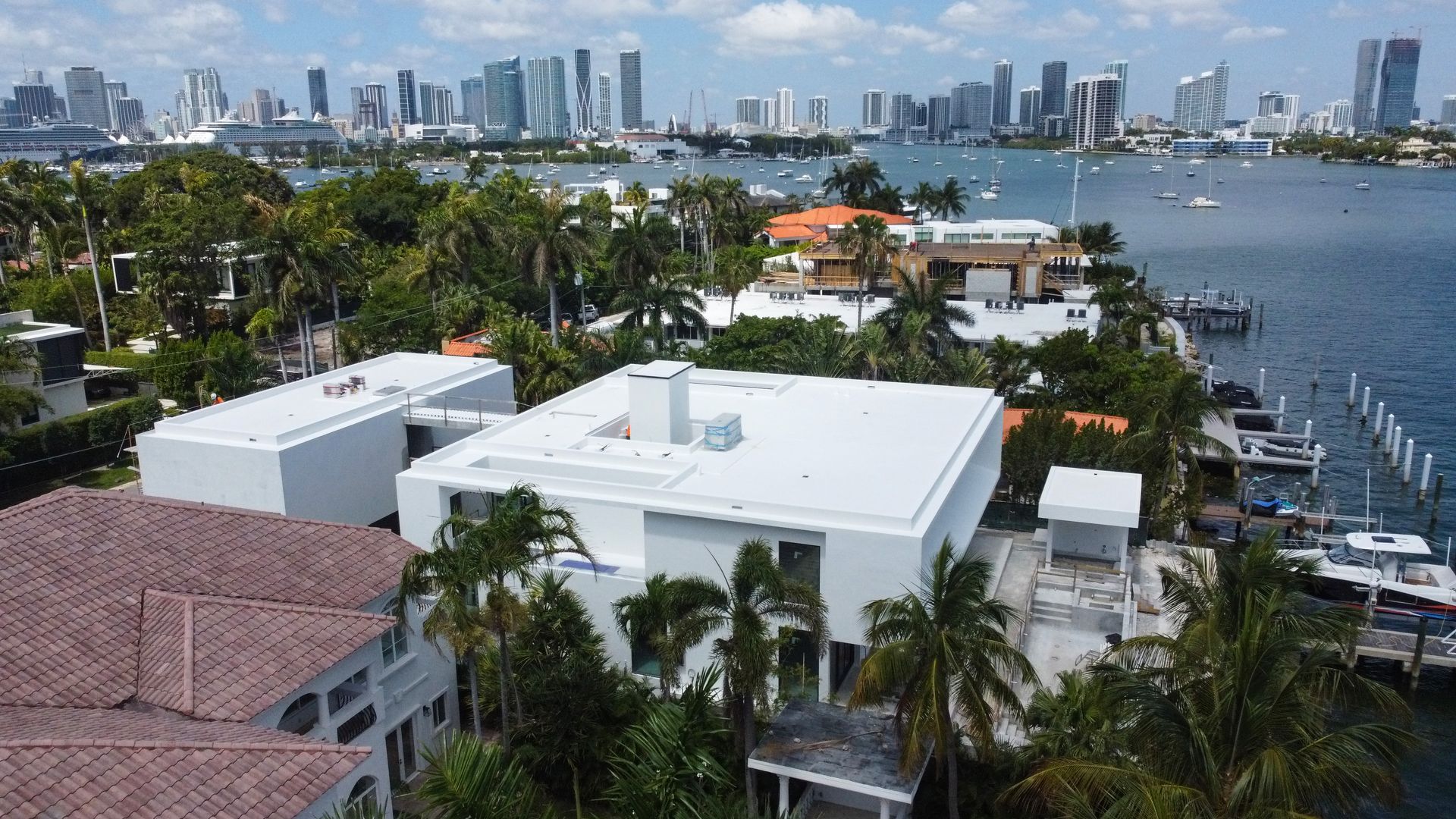 An aerial view of a city with a large white house in the foreground