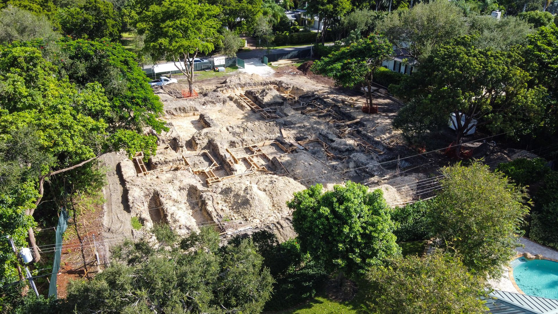 Aerial view of a construction site cleared of vegetation; surrounded by trees.