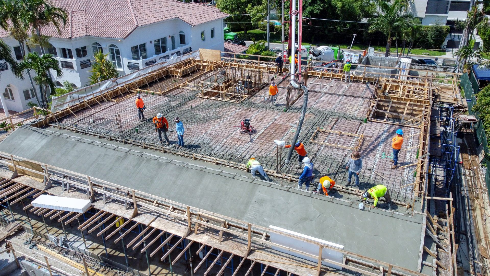 An aerial view of a construction site with workers pouring concrete.