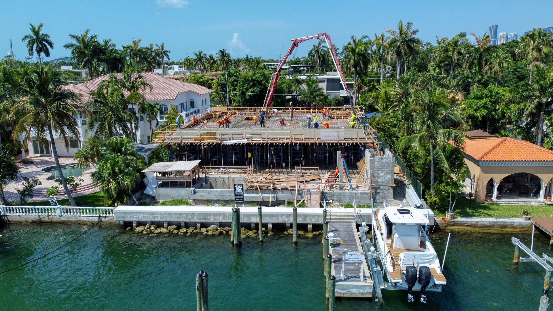 An aerial view of a building under construction next to a body of water.