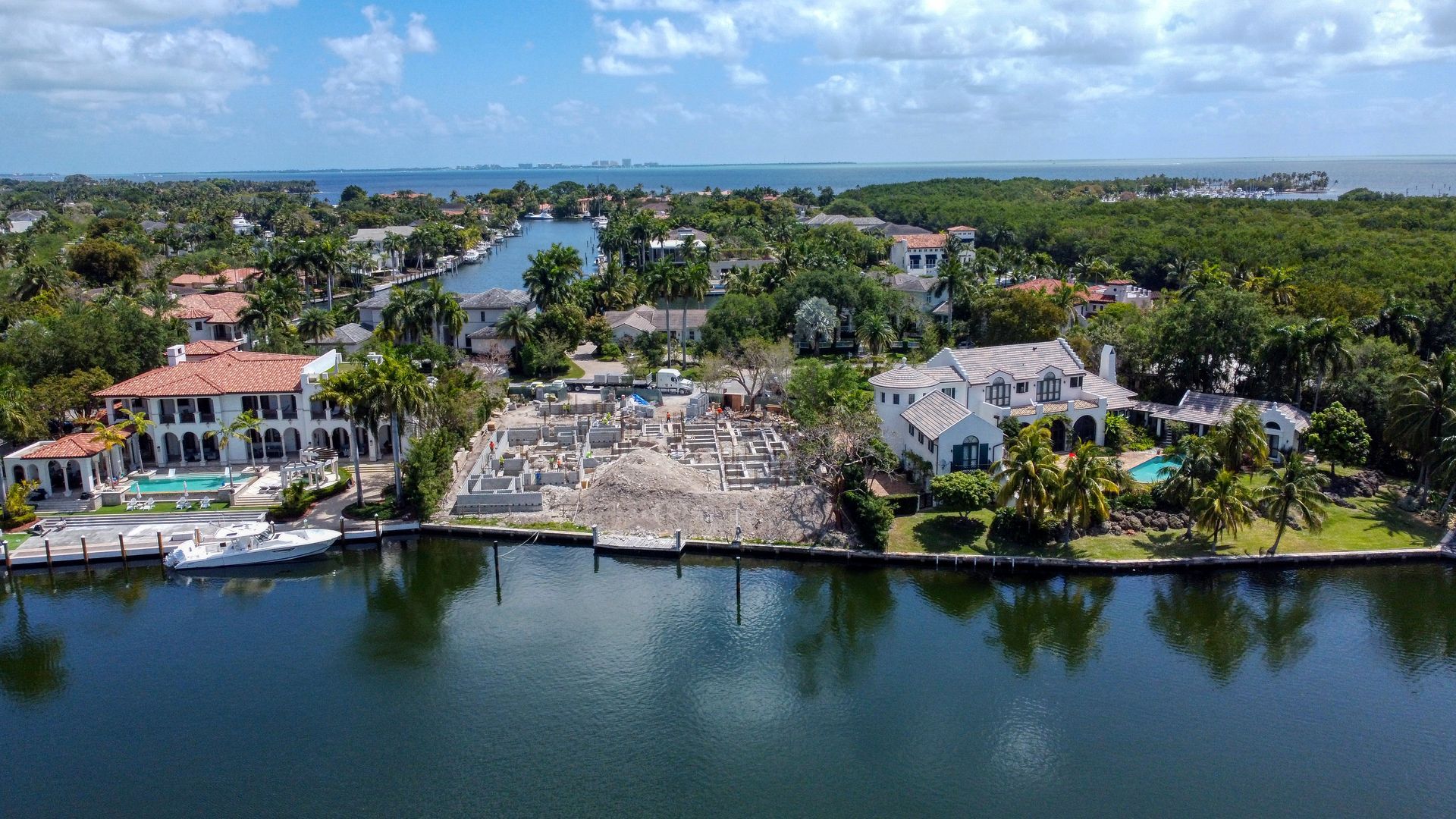 Waterfront houses in a sunny setting with construction in the center.