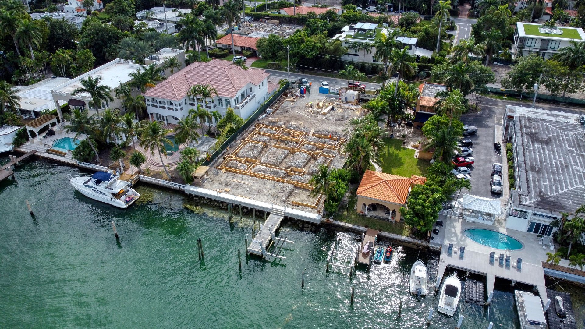 An aerial view of a residential area next to a body of water with boats docked.