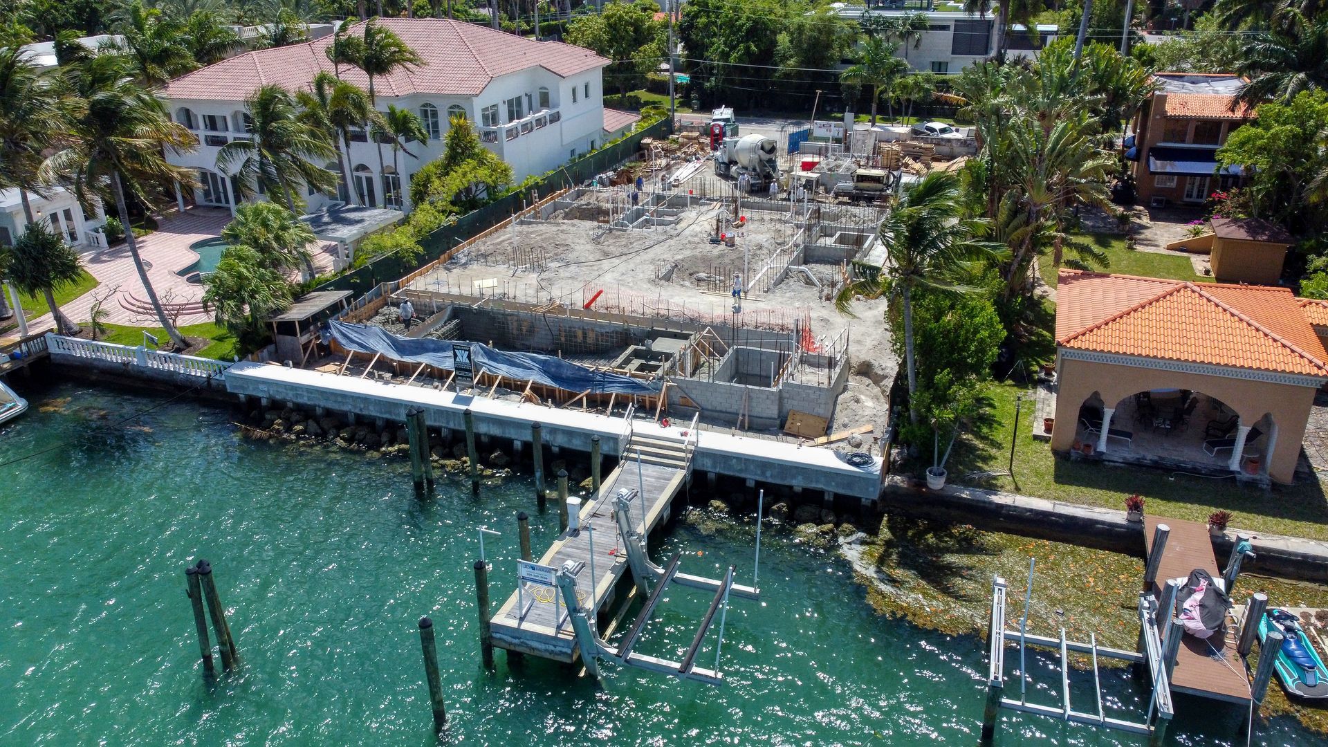 An aerial view of a large body of water with a dock and houses in the background.